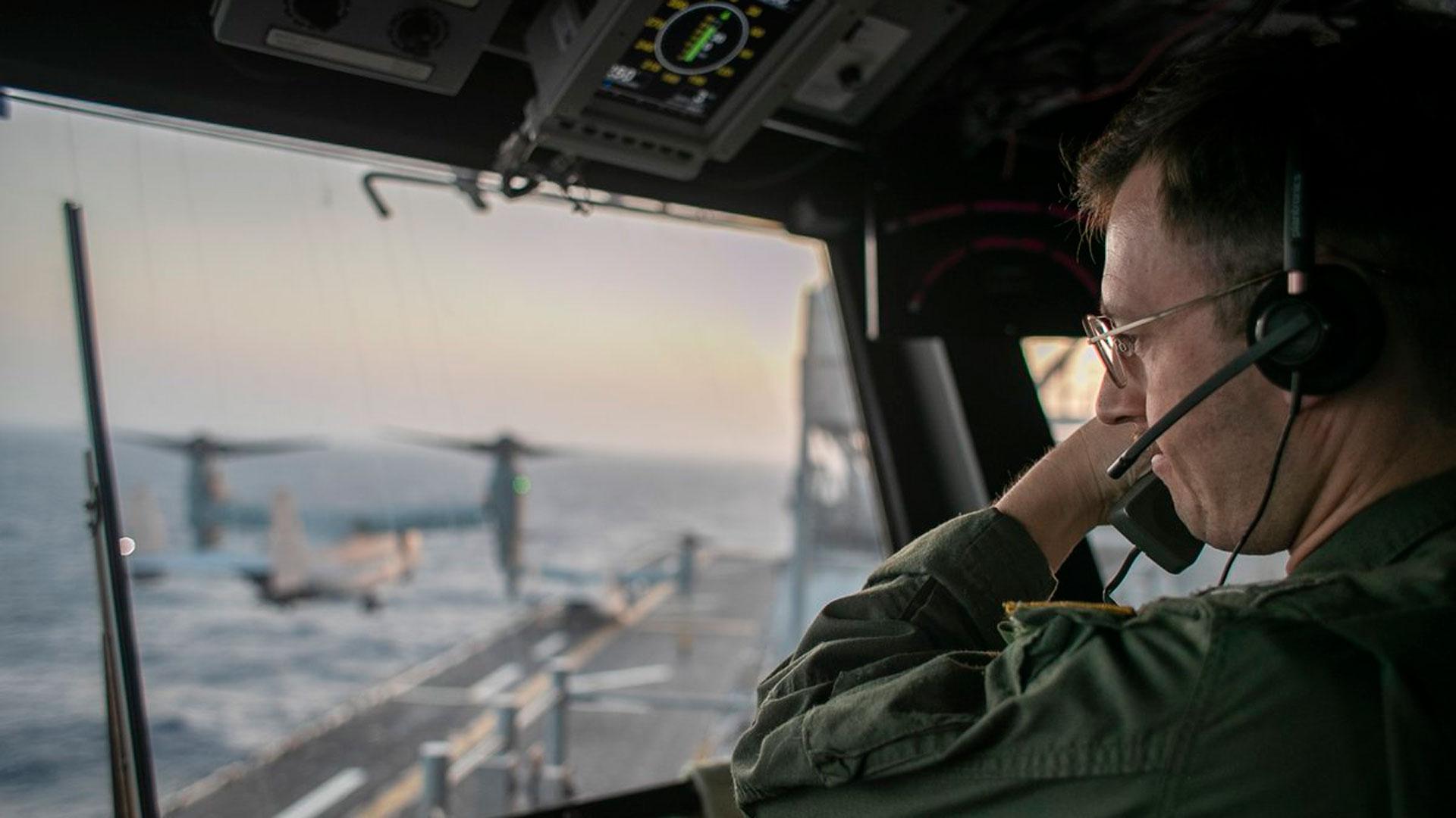 Un oficial naval a bordo del USS Tripoli supervisa las operaciones de vuelo desde la torre de control mientras el buque de asalto anfibio navega en el mar Arábigo