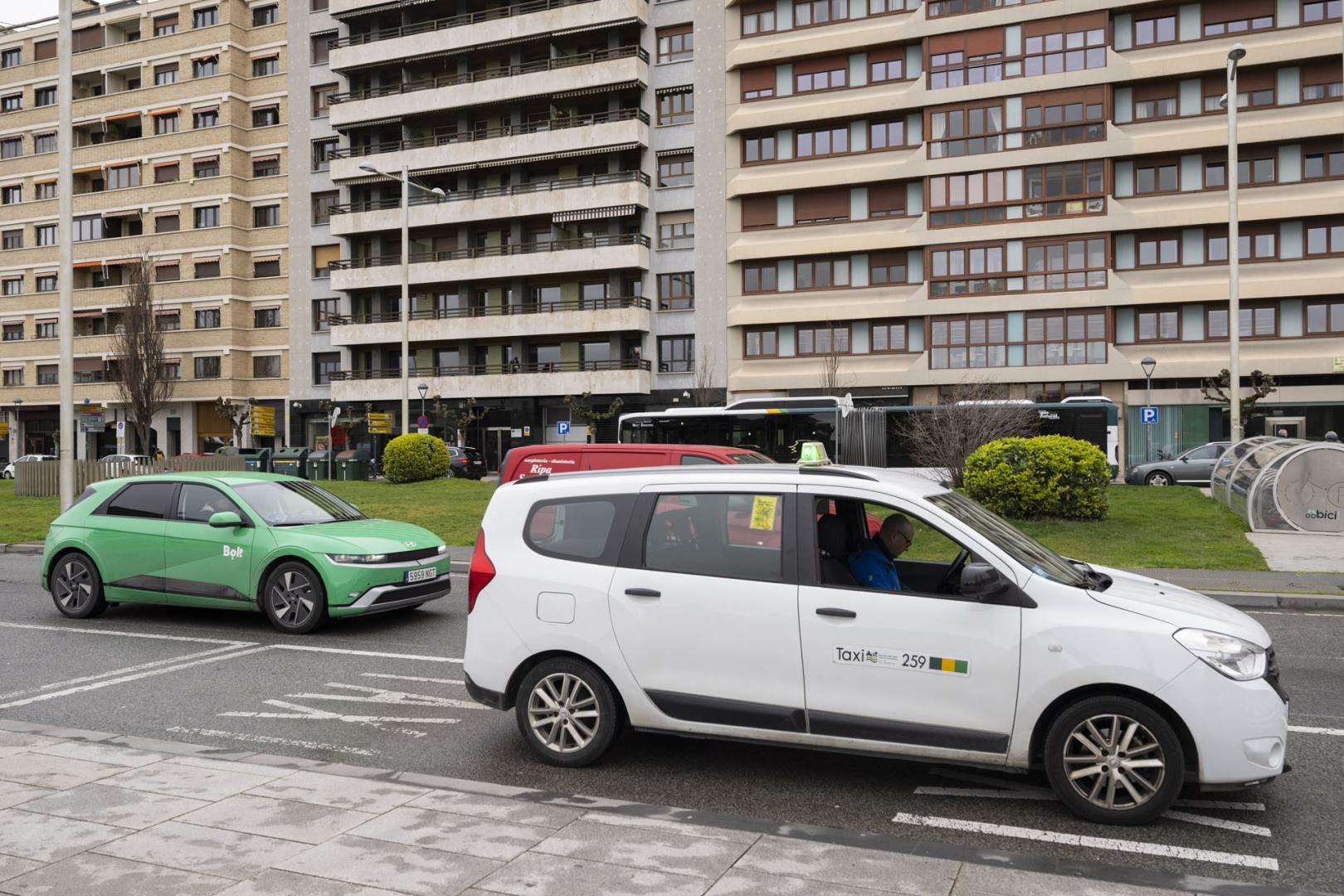 Un vehículo de la plataforma Bolt circula junto a una parada de taxi en Pamplona