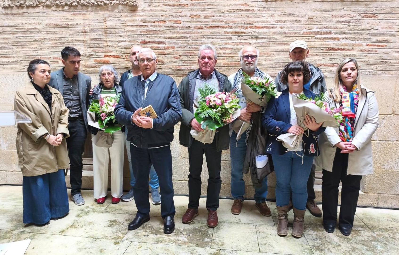 Con los obsequios y flores, desde la izda., Bernarda Urra, herida en Montejurra; José Luis y Miguel García Pellejero, hermanos de Ricardo; Josu Herce, herido en los sucesos; e Itziar Maya, sobrina de Ricardo. Todos ellos fueron homenajeados en la casa de cultura de Estella
