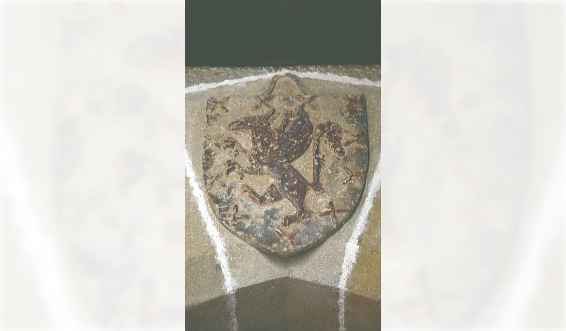 Escudo de Pierres de Peralta en la puerta del castillo de Marcilla. La descripción heráldica del escudo sería la siguiente: bordura en gules con 8 aspas de San Andres en oro. Fondo de gules con grifo rampante de oro