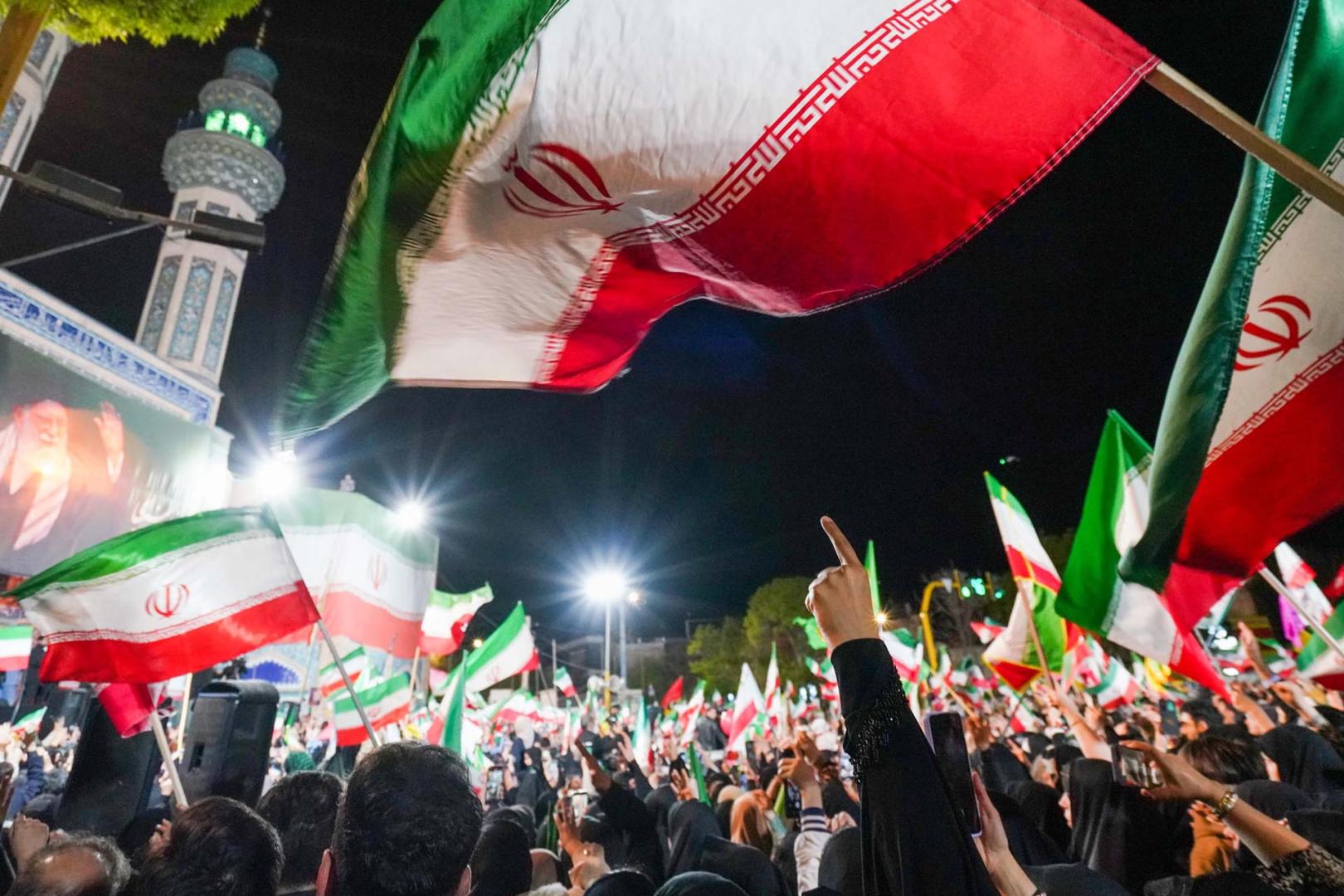 Partidarios del gobierno iraní ondean banderas nacionales durante una manifestación