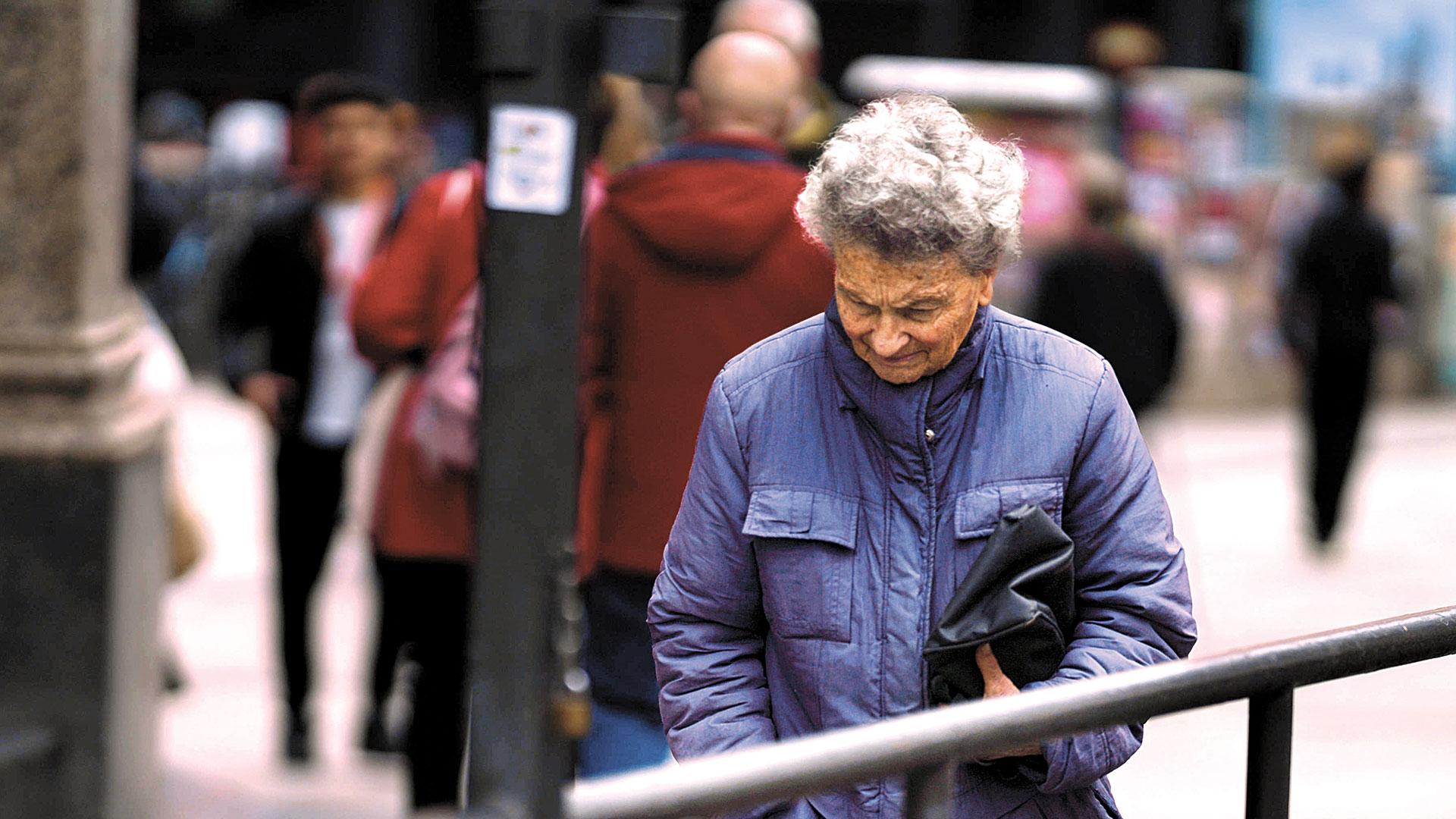 Una pensionista pasea por las calles de Madrid
