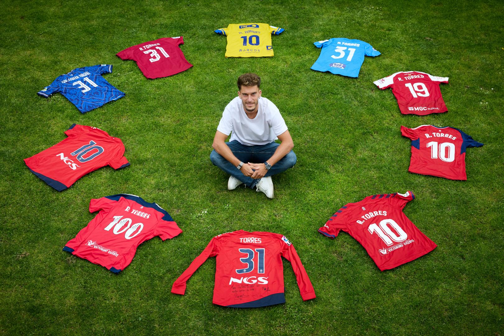 Roberto Torres posa en Arre con camisetas representativas de su carrera:la del filial, la del debut, la de los dos ascensos, la última con Osasuna y las de los cinco equipos posteriores, Foolad, Gol Gohar, Inter Escaldes, Nástic y Orihuela.