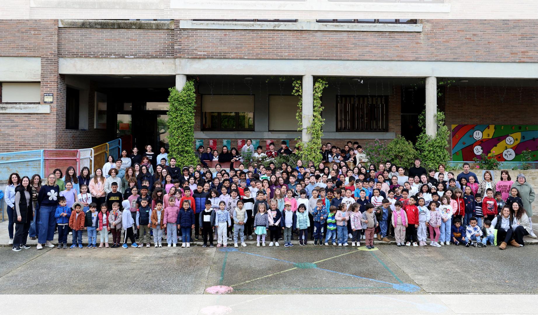 Escolares y equipo docente del colegio público Doña Álvara Álvarez de Falces se fotografiaron ayer frente a la entrada del centro.