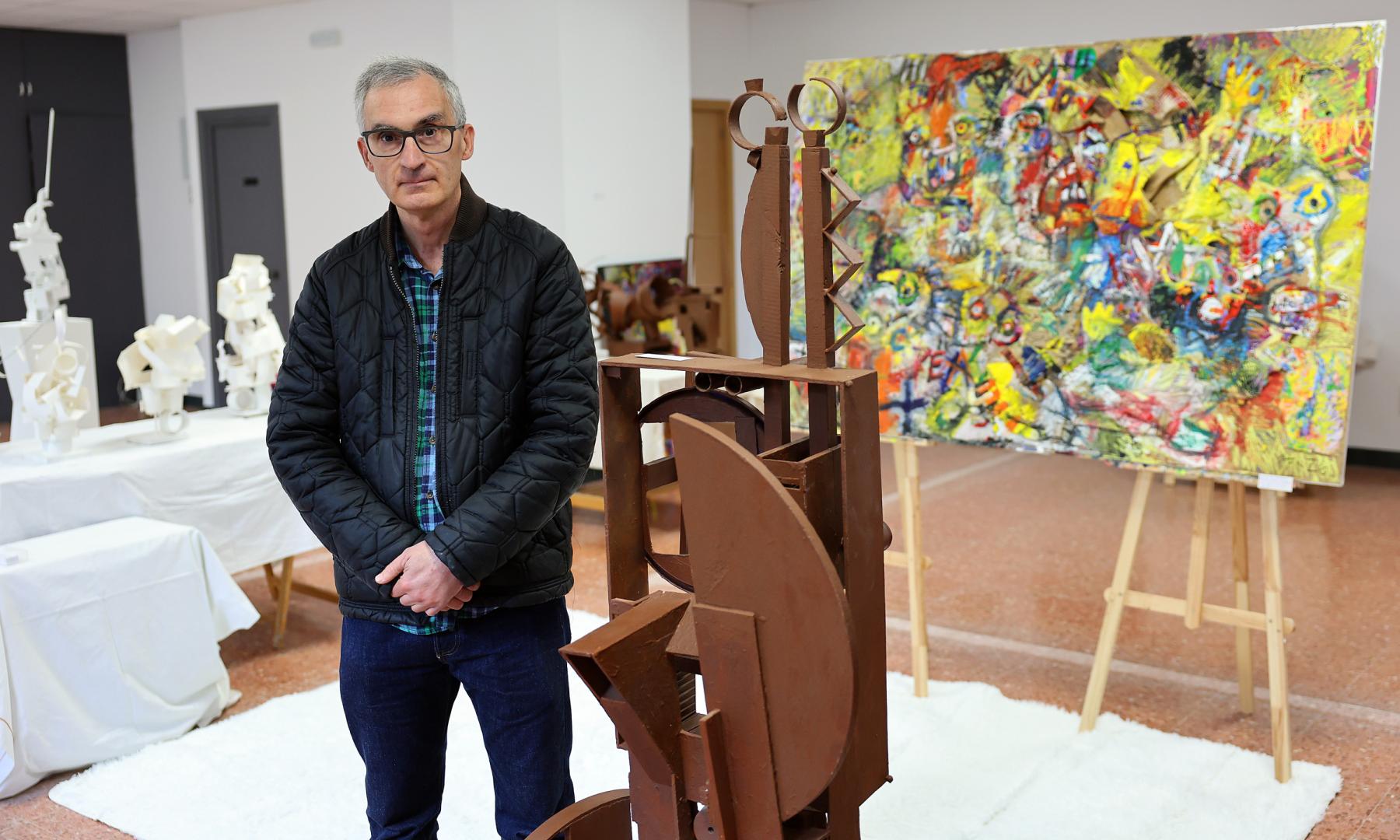 Pablo Ferrer, posando junto a las obras que muestra en la exposición 'Momentos sin ruido'. Al fondo, el lienzo 'Lucha de gigantes'.
