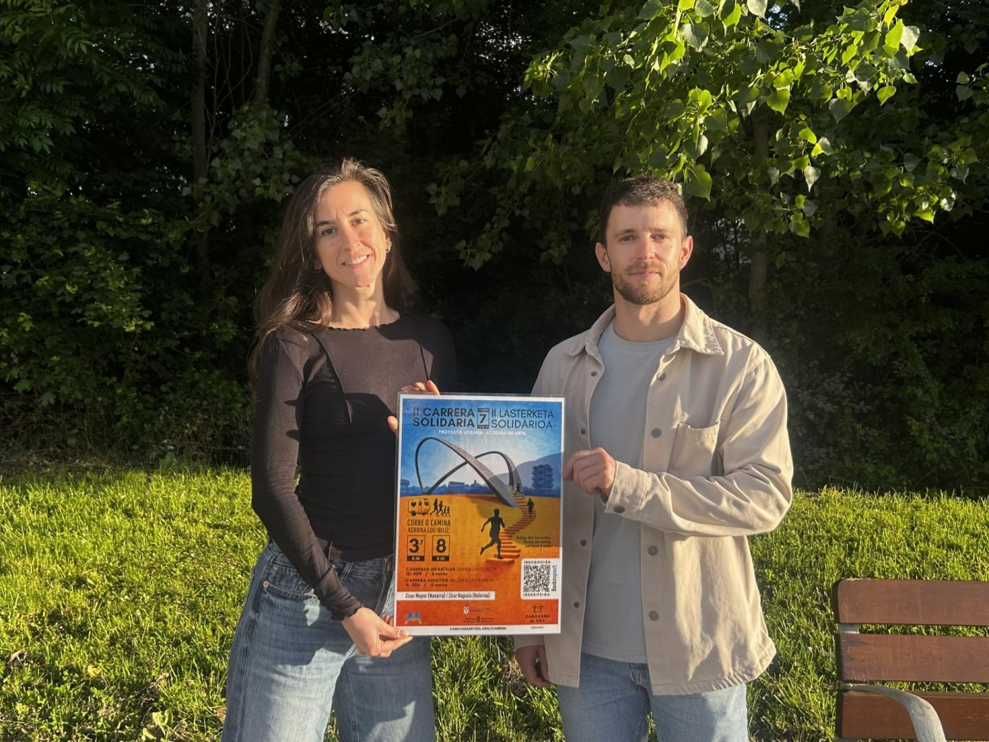 Clara Ilundáin y Guillermo Urmeneta, voluntarios de Caravana de Vida, con el cartel de la nueva edición