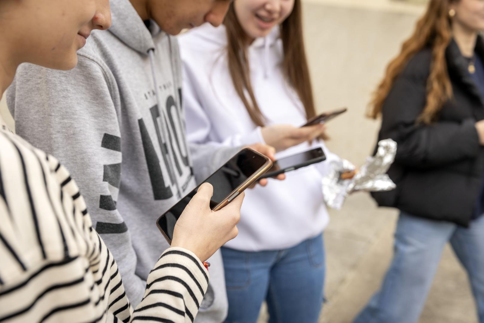 Un grupo de adolescentes consulta su teléfono móvil durante un recreo, en el colegio FEC Vedruna de Pamplona.
