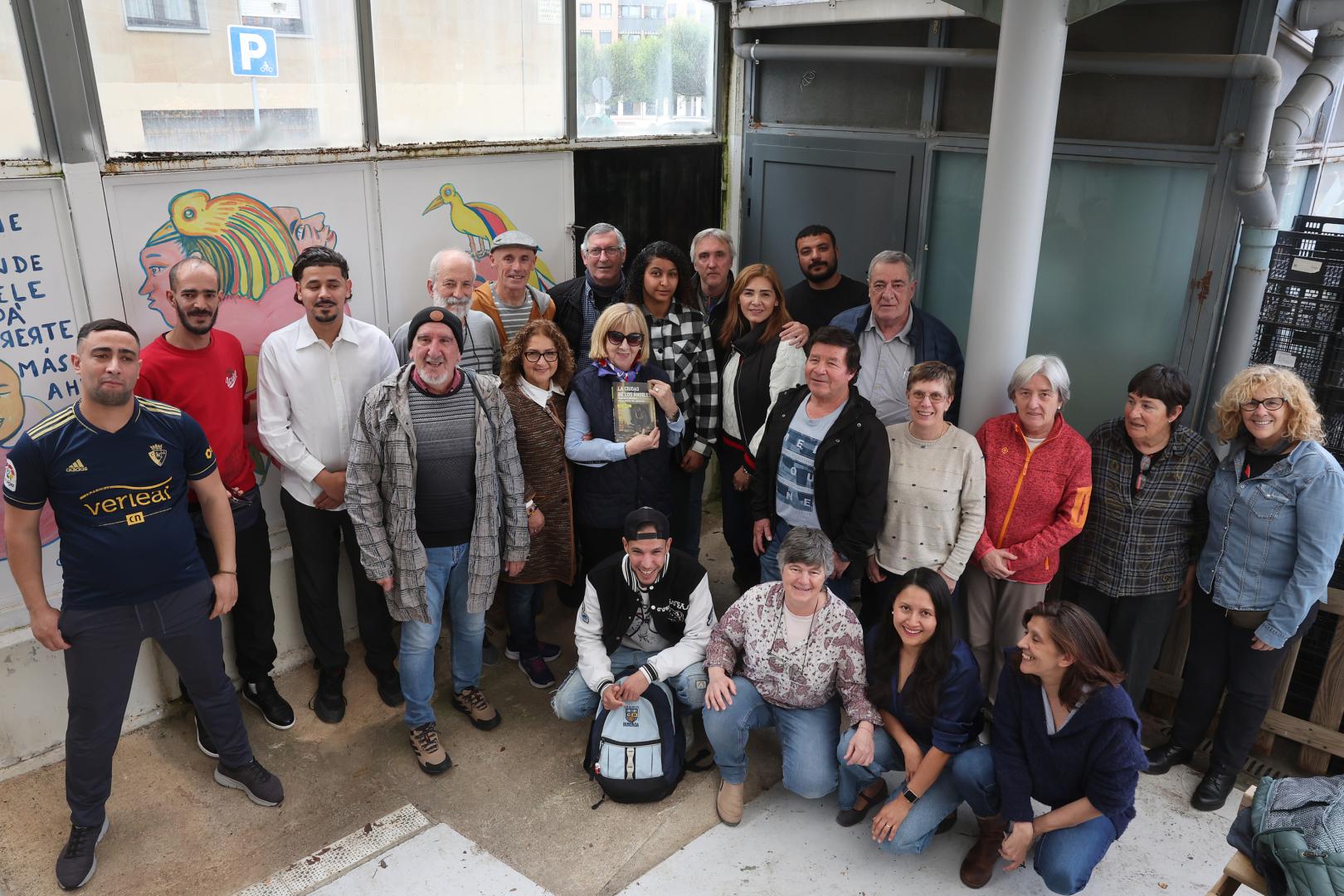 Voluntarias y voluntarios de la asociación Apoyo Mutuo, con el libro de Iván Benítez.
