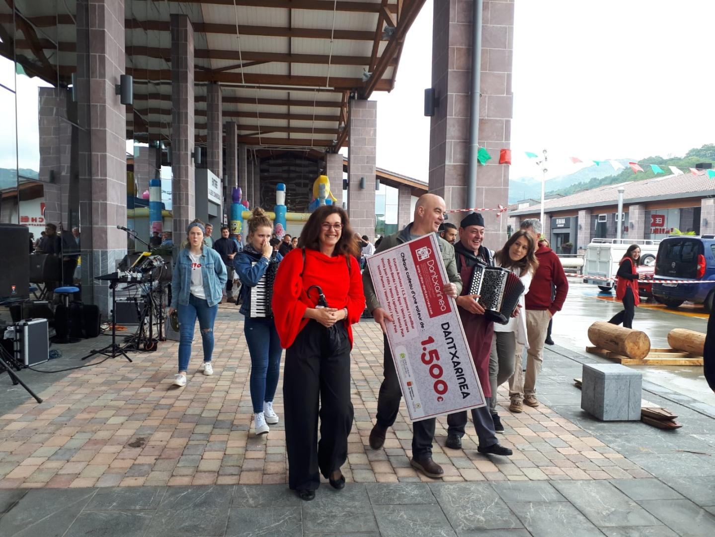 Imagen de una edición anterior de la fiesta de pentecostés en Dantxarinea, con la entrega del cheque de 1.500 euros al ganador del sorteo por parte del presidente de la Asociación de Comerciantes, Txomin Iriarte.