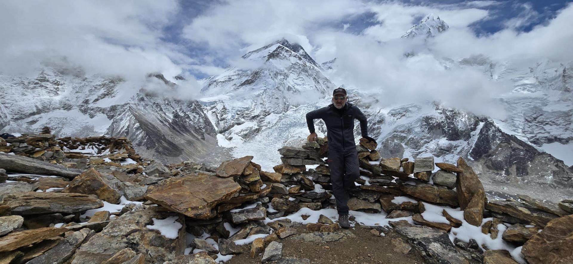 Óscar Arroyo Úbeda, con la cumbre del Everest a su espalda asomando entre las nubes