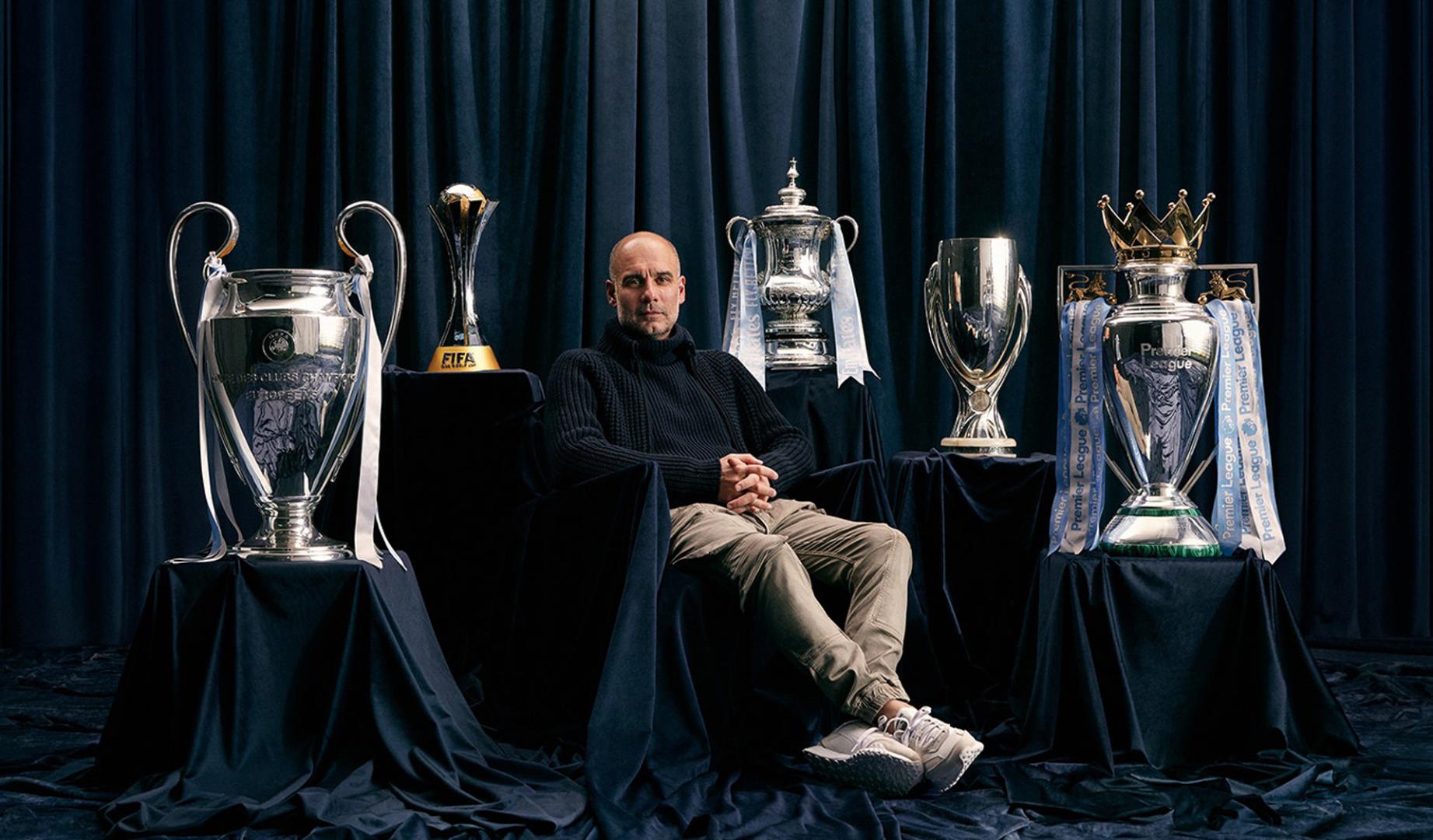 Pep Guardiola posa junto a los títulos conseguidos con el Manchester City