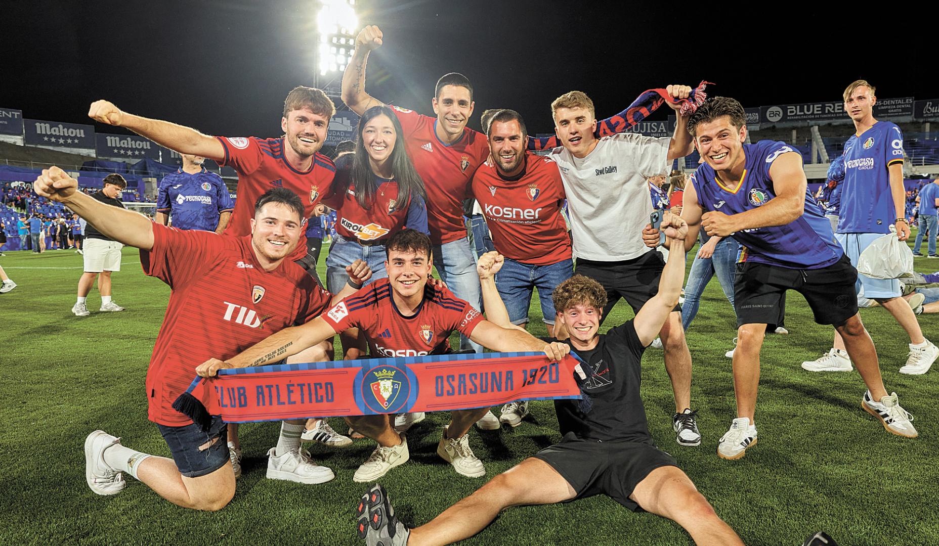 Un grupo de aficionados en el césped del Coliseum de Getafe
