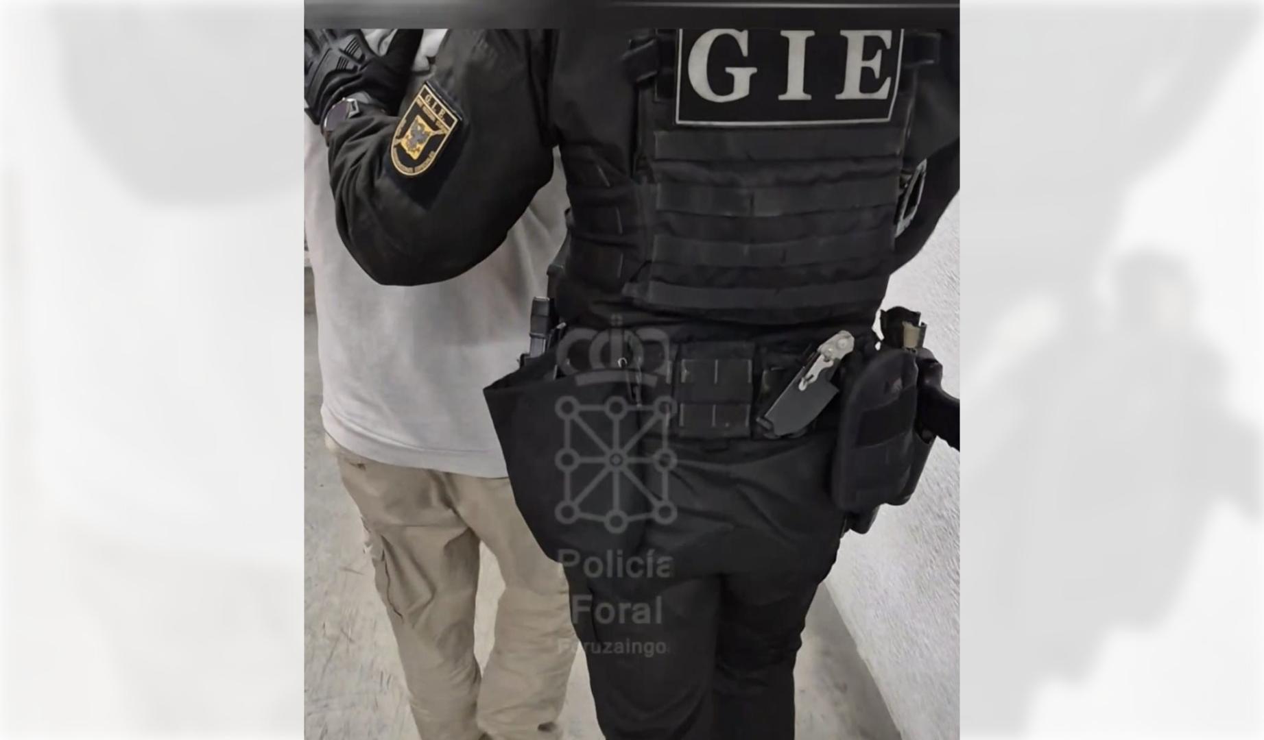 Un agente de la Policía Foral conduce al detenido