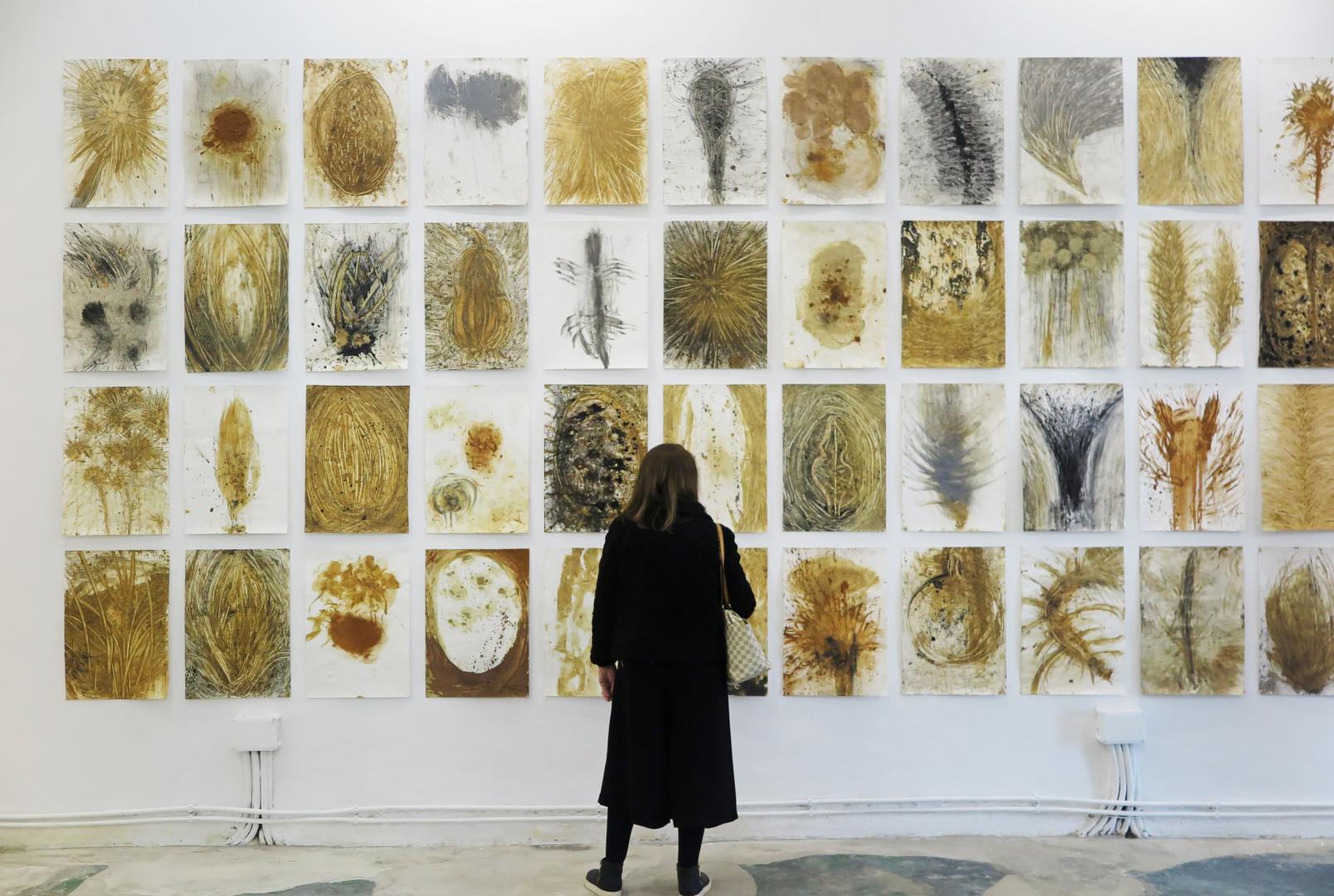 Una visitante observa las obras de la exposición Nacimiento y muerte en la montaña en la galería coruñesa Nordés