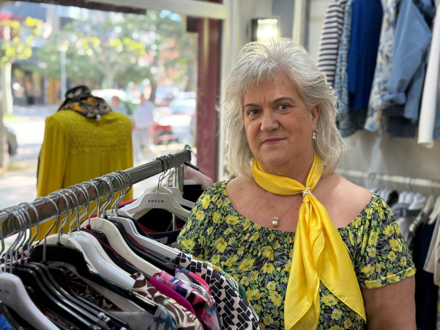 Pili Zugaldía junto al escaparate y prendas de ropa en la tienda que lleva su nombre