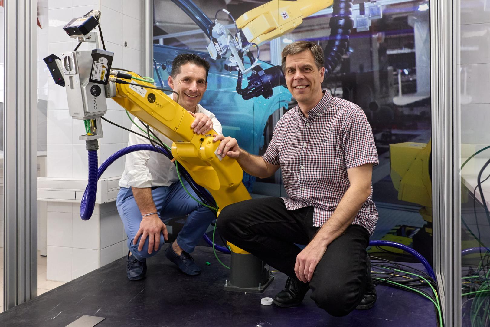 Eduardo Azanza e Israel Arnedo posan con un robot equipado con el cabezal que permite medir el espesor de la pintura