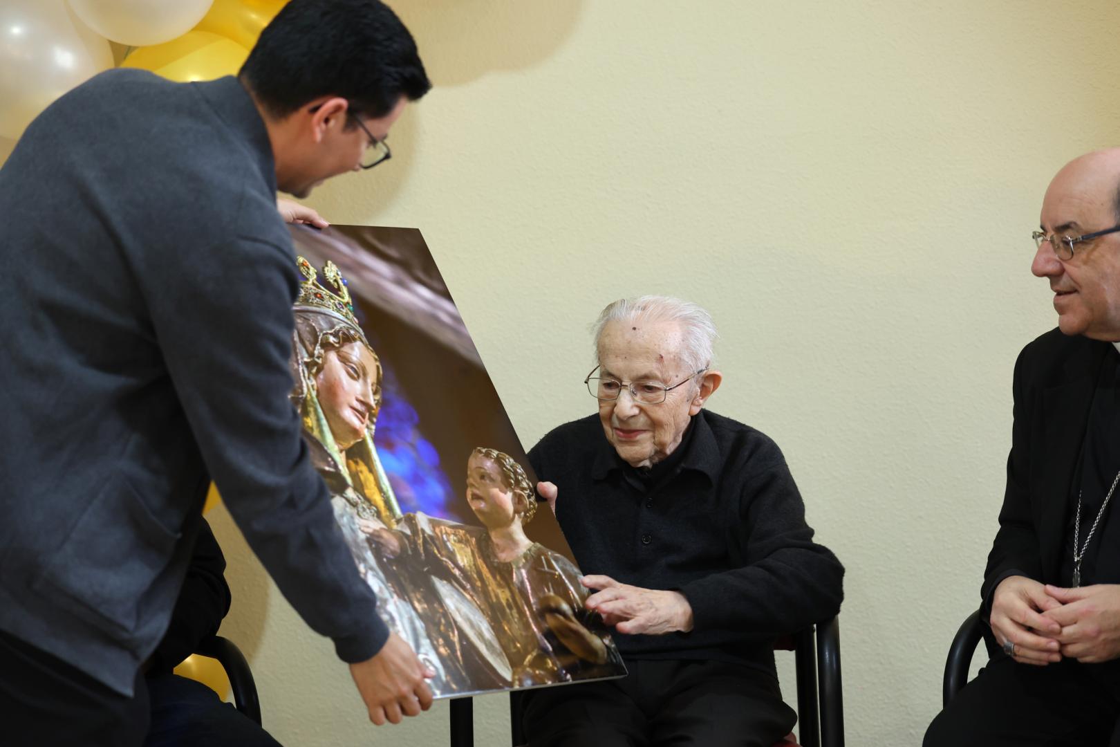 Jesús Labiano recibe una imagen de la virgen del Roncesvalles de manos del sacerdote Carlos Martínez y junto al arzobispo de Pamplona, Florencio Roselló.
