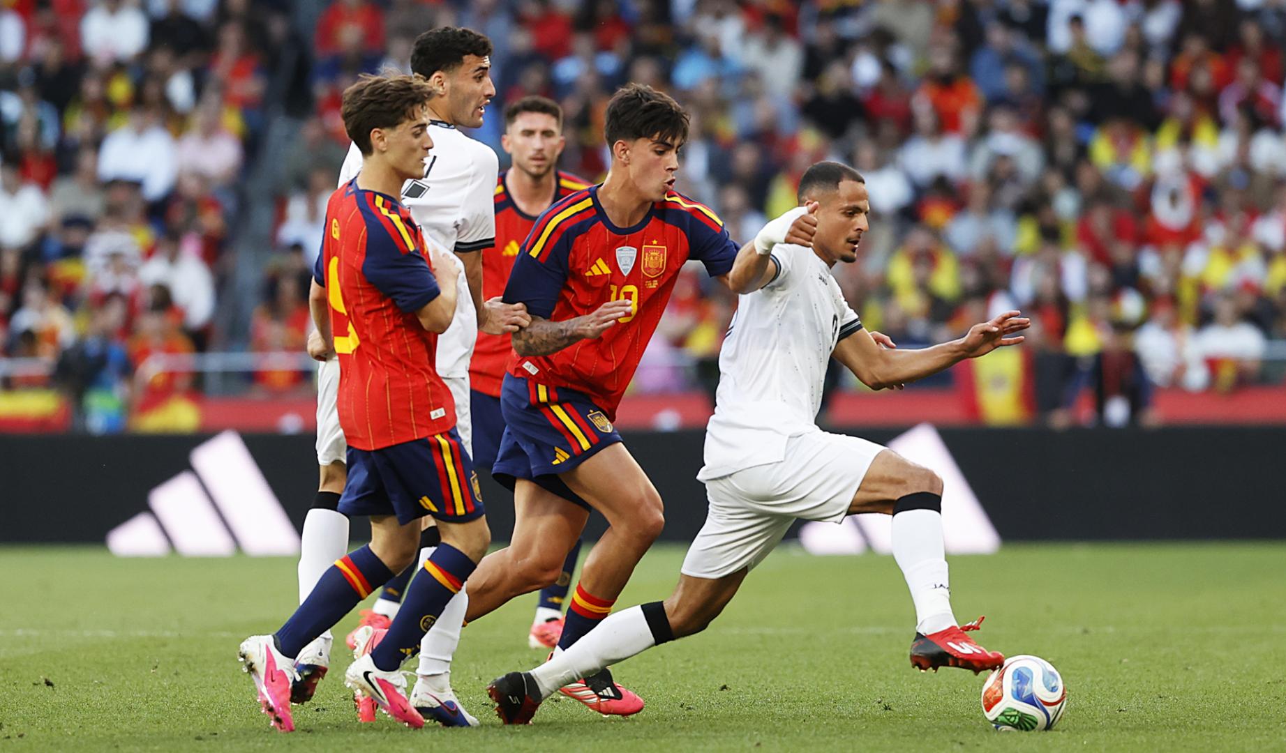 Marc Bernal, junto a Gavi, persigue al iraquí Ali Al Hamadi durante el partido
