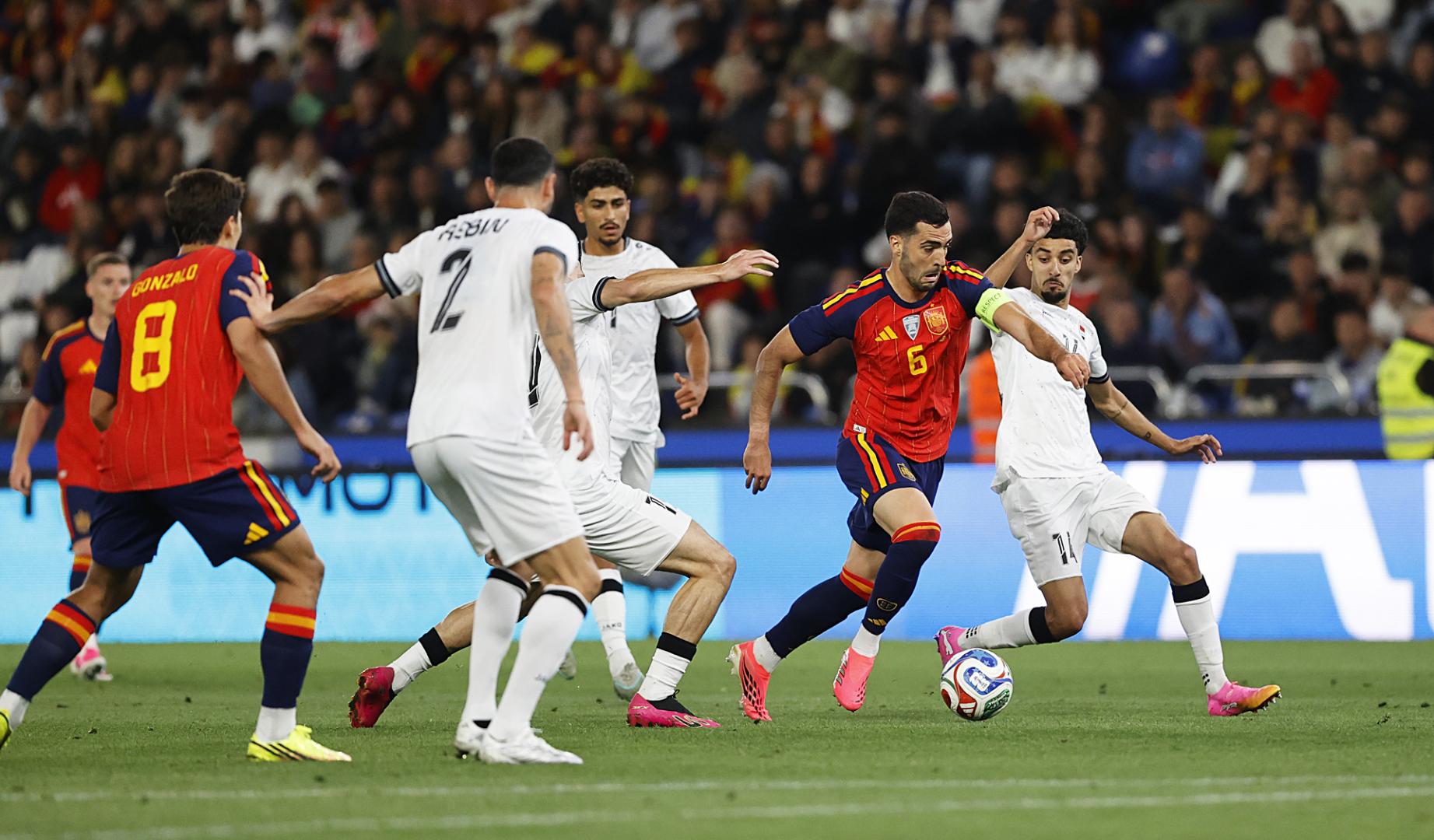 El centrocampista español Mikel Merino conduce el esférico entre rivales de Irak