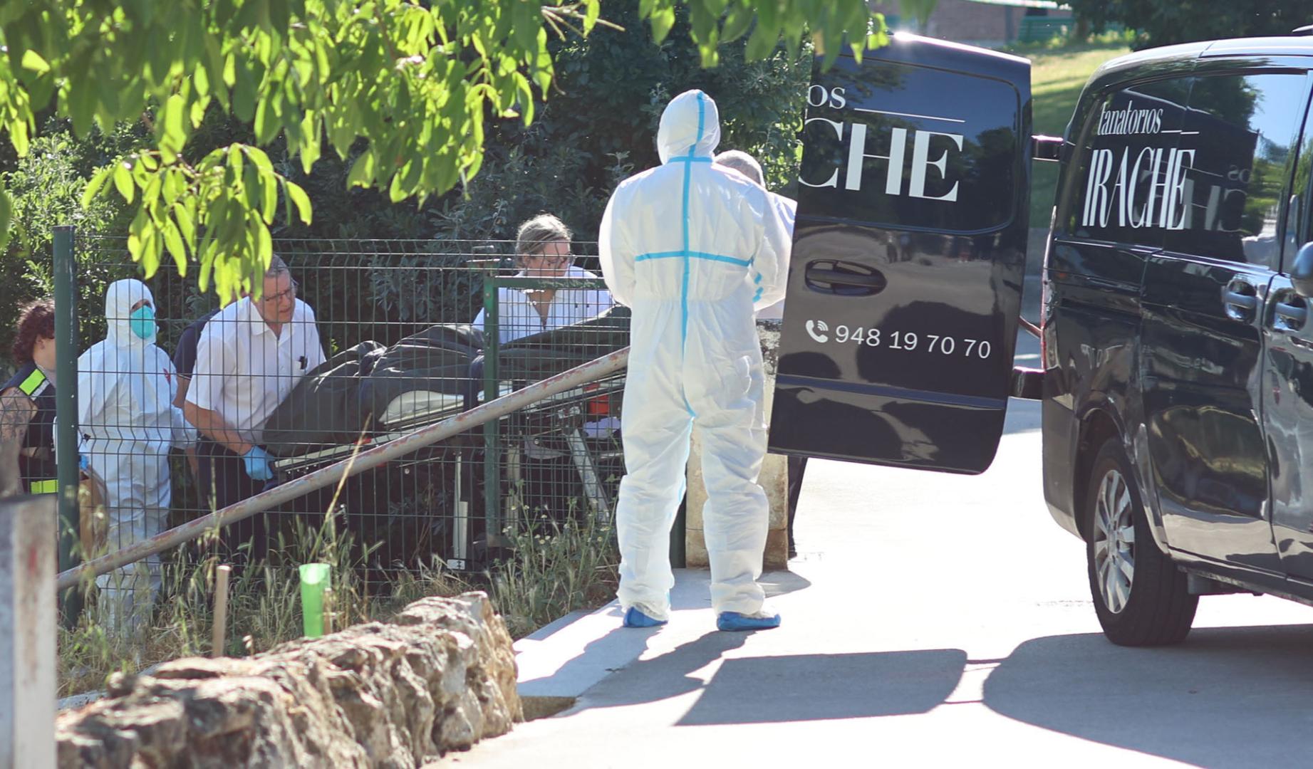 Trabajadores de la funeraria trasladan el cuerpo