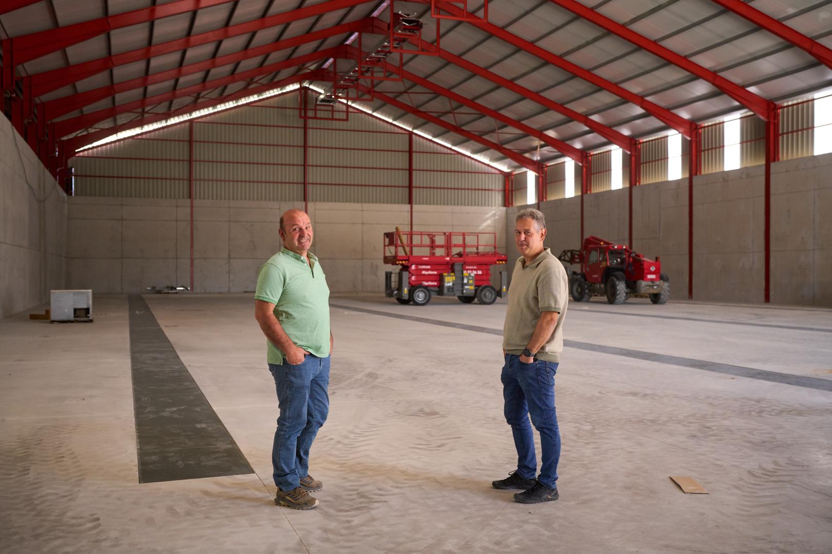 Francisco Javier Artajo Carlos (izda.) y José Luis Pemán Calvo, presidente y gerente de la Sociedad Cooperativa Cerealista de Sangüesa, dentro de la nueva nave de almacenamiento de cereal en construcción