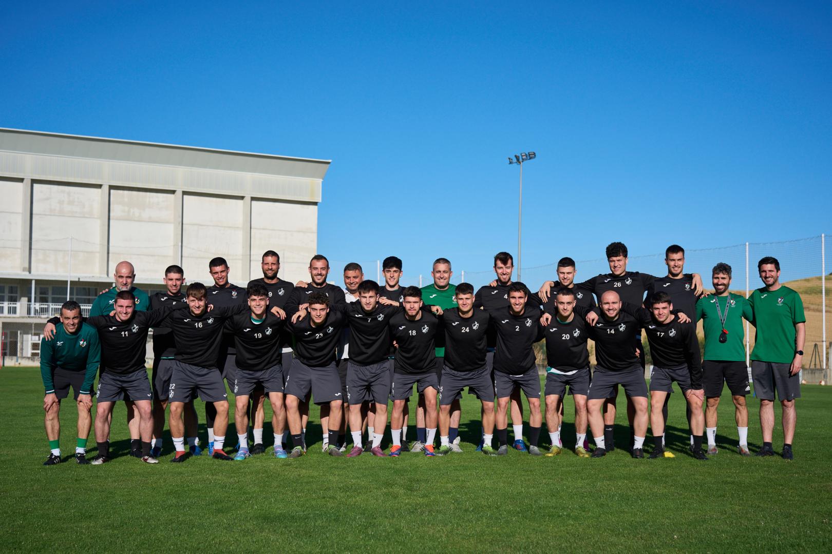 Los jugadores y el cuerpo técnico del Pamplona posan en el campo de fútbol de El Pontarrón de Mendigorría donde han entrenado el miércoles y el jueves