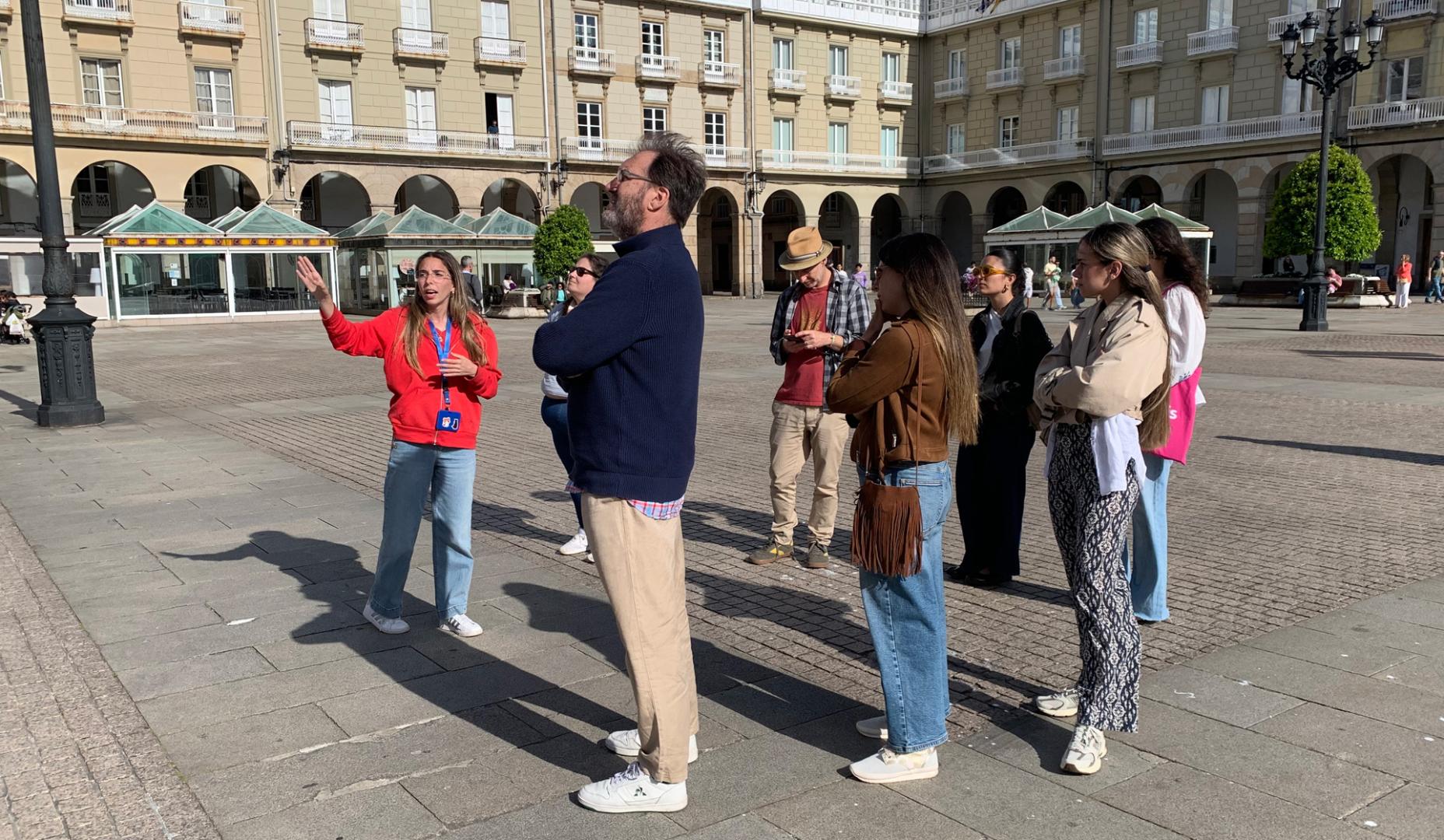 Un grupo de personas atiende las explicaciones de una organizadora en A Coruña