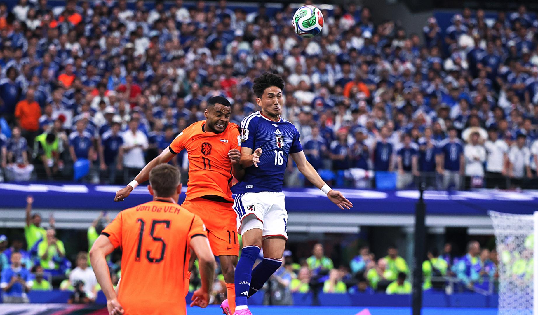 Cody Gakpo (izda.) de Países Bajos disputa el balón con Tsuyoshi Watanabe (dcha.) de Japón