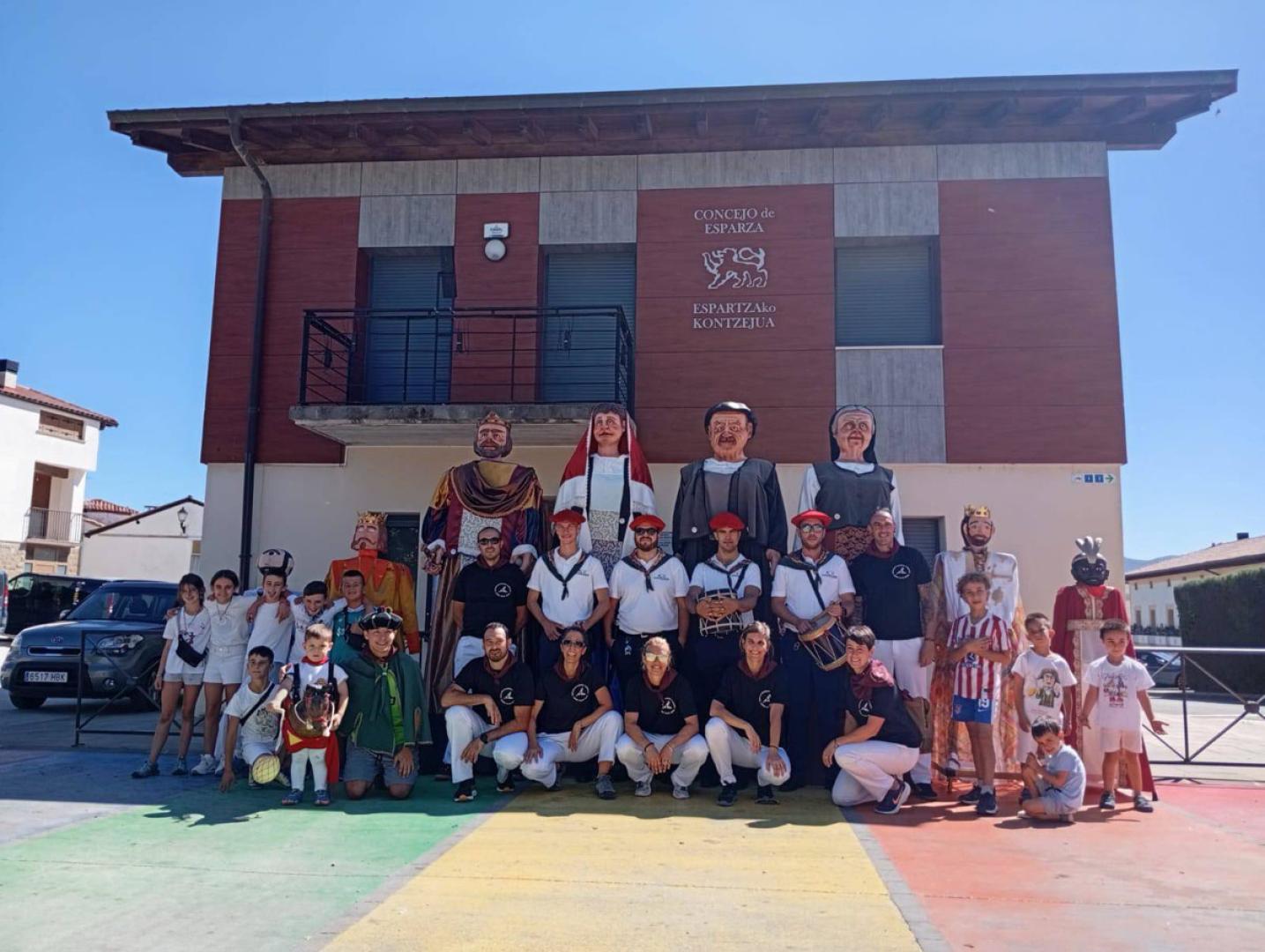 Foto de familia de la comparsa, en compañía de los gaiteros y de los pequeños que les acompañan con sus propias réplicas de las figuras