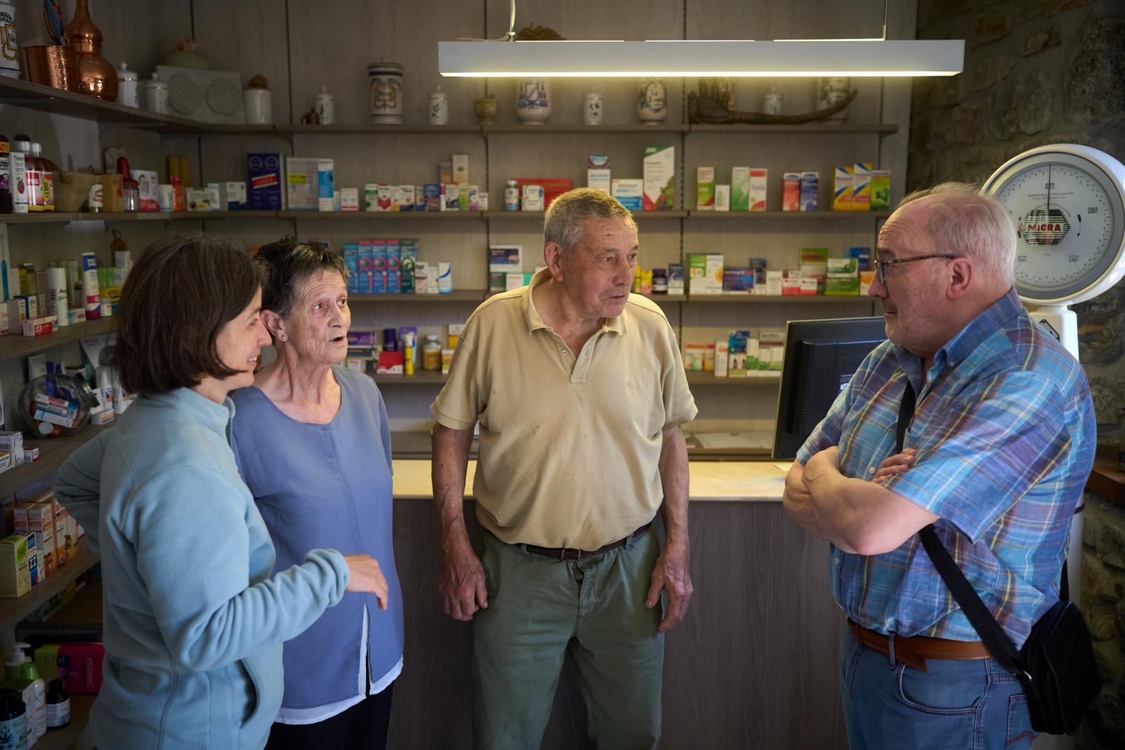 Desde la izda., la farmacéutica de Ezcároz Pepa Vicente Collado, y los clientes Rosa Anaut Petroch, Jaime Eseberri Barber y Alejandro Torrea, comentando la noticia de la visita de un oso al pueblo