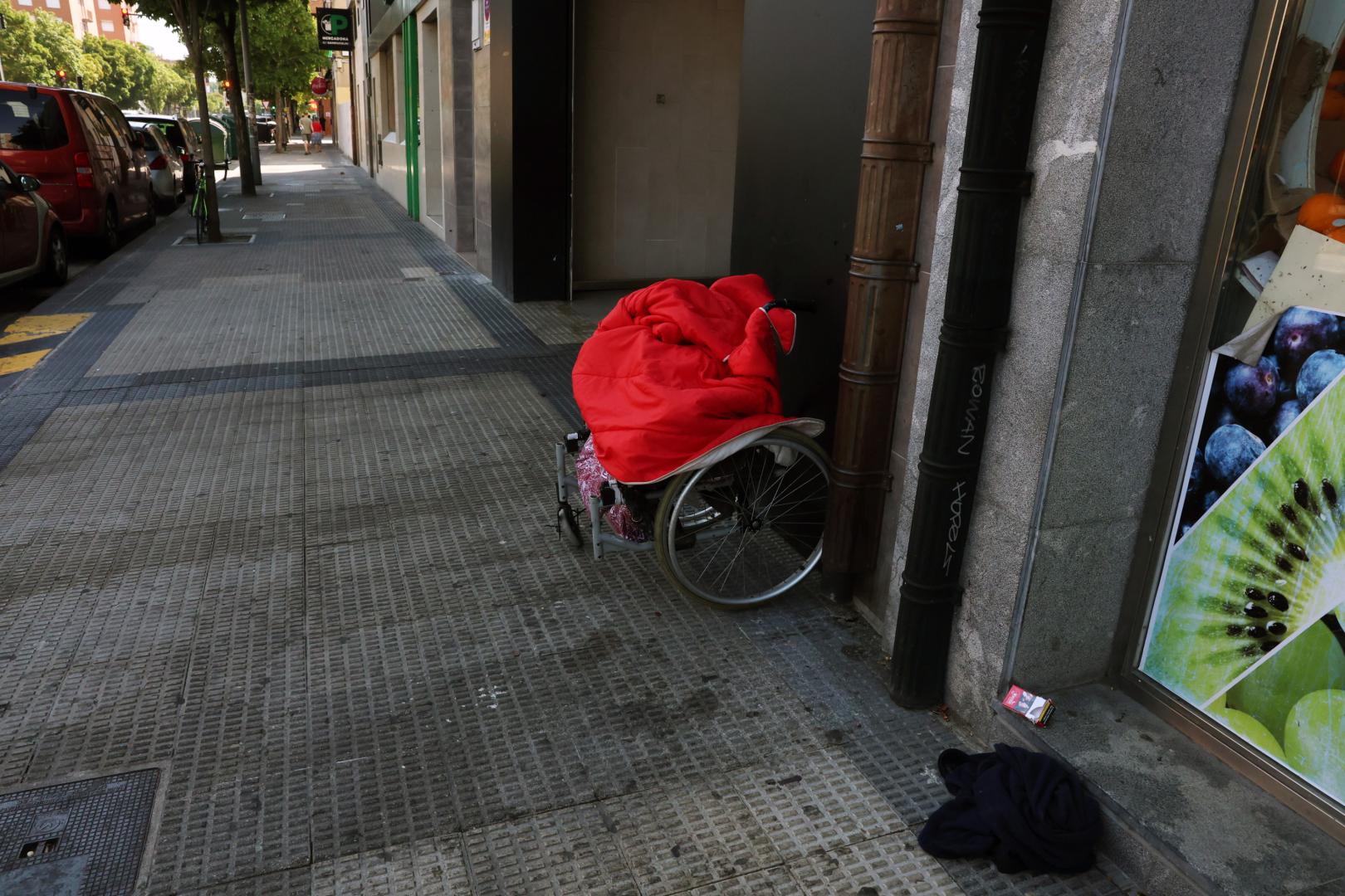 Silla de ruedas que utilizaba M. para pedir, este martes por la mañana en el lugar donde fue apuñalado el lunes.
