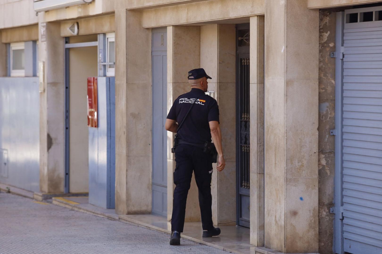 Un agente accede al edifico donde la Policía Nacional ha hallado el cadáver de un varón en una nevera en un piso en la ciudad de Castellón