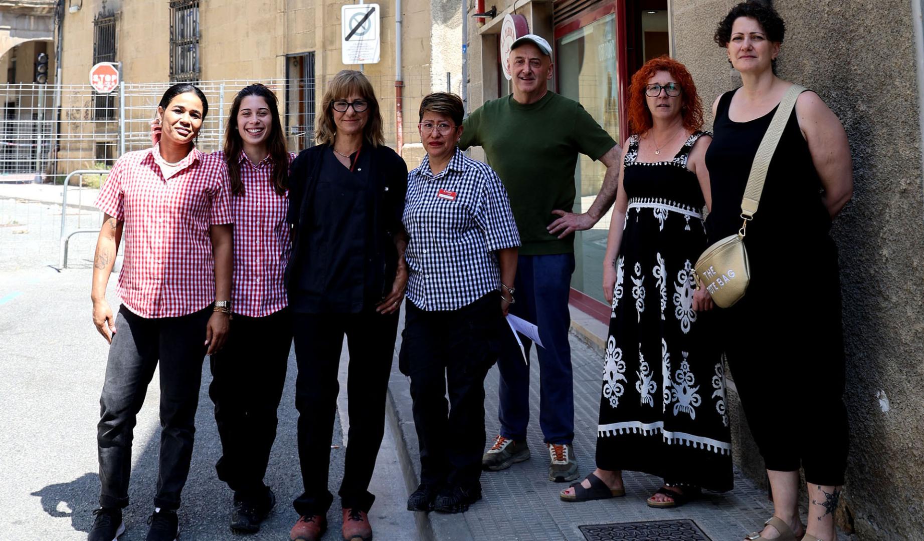Comerciantes y trabajadoras de la avenida Diputación Foral delante de la valla que cierra la calle para proteger Casa Mendoza