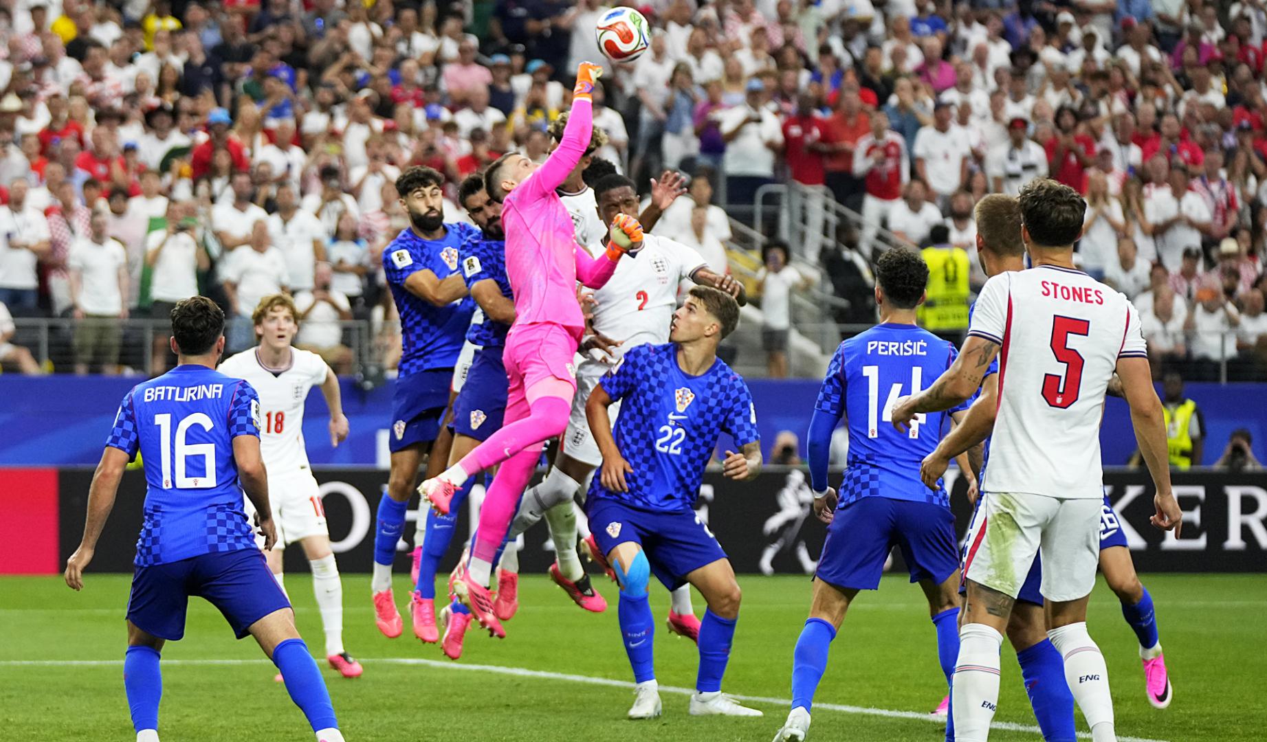 El meta croata Dominik Livakovic, que realizó un buen encuentro pese a la derrota, despeja de puños un envío al área de Inglaterra