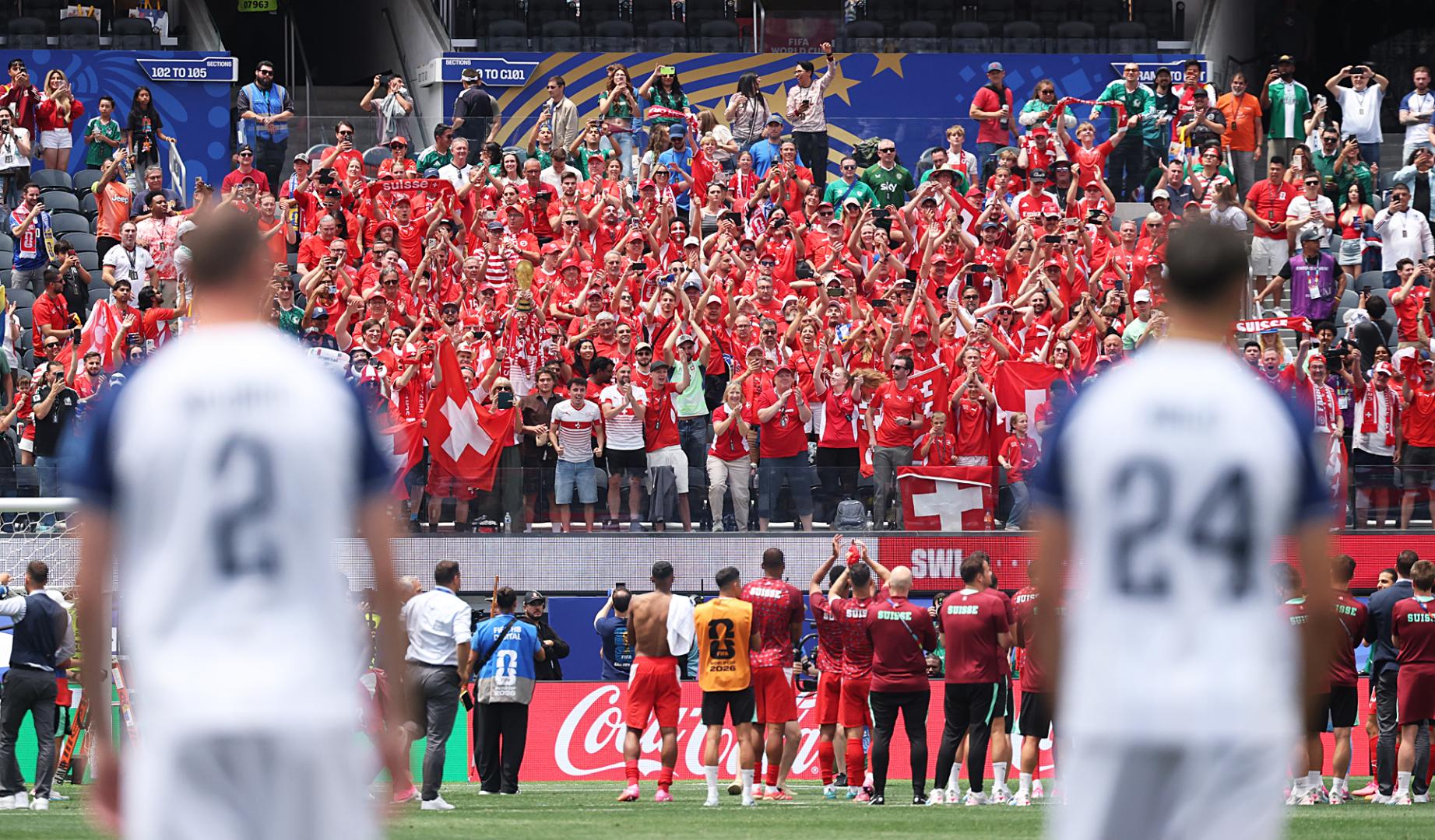 Los jugadores suizos celebran con su afición la victoria ante la desolación de los bosnios