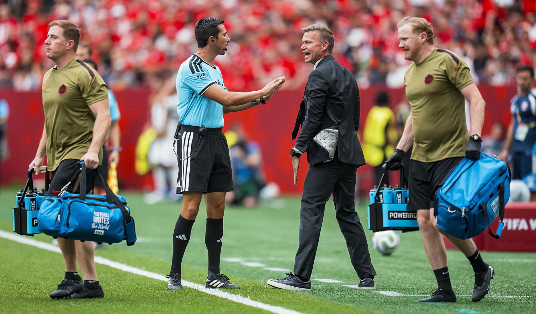 El técnico de Canadá habla con uno de los asistentes durante el choque contra Catar
