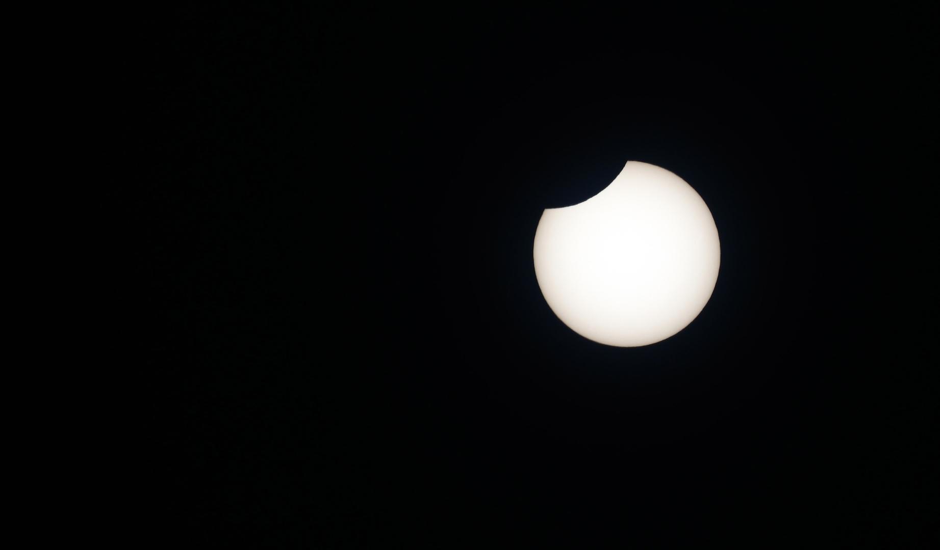 La luna ocultando el sol en un eclipse parcial en Pamplona, en la explanada del Planetario, el 11 de junio de 2021