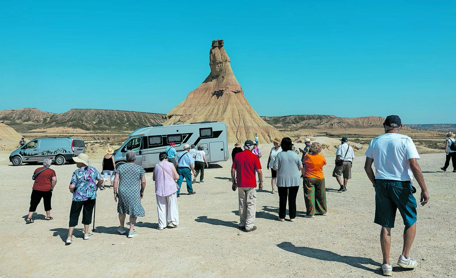Un grupo de turistas se para a observar Castildetierra durante su excursión en las Bardenas Reales