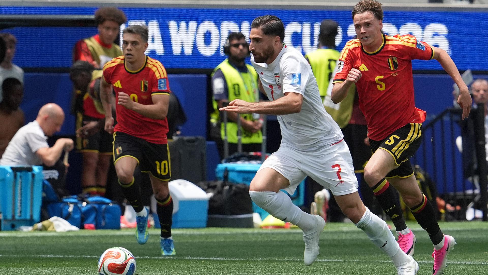 Maxim De Cuyper (d) de Bélgica disputa el balón con Alireza Jahanbakhsh de Irán