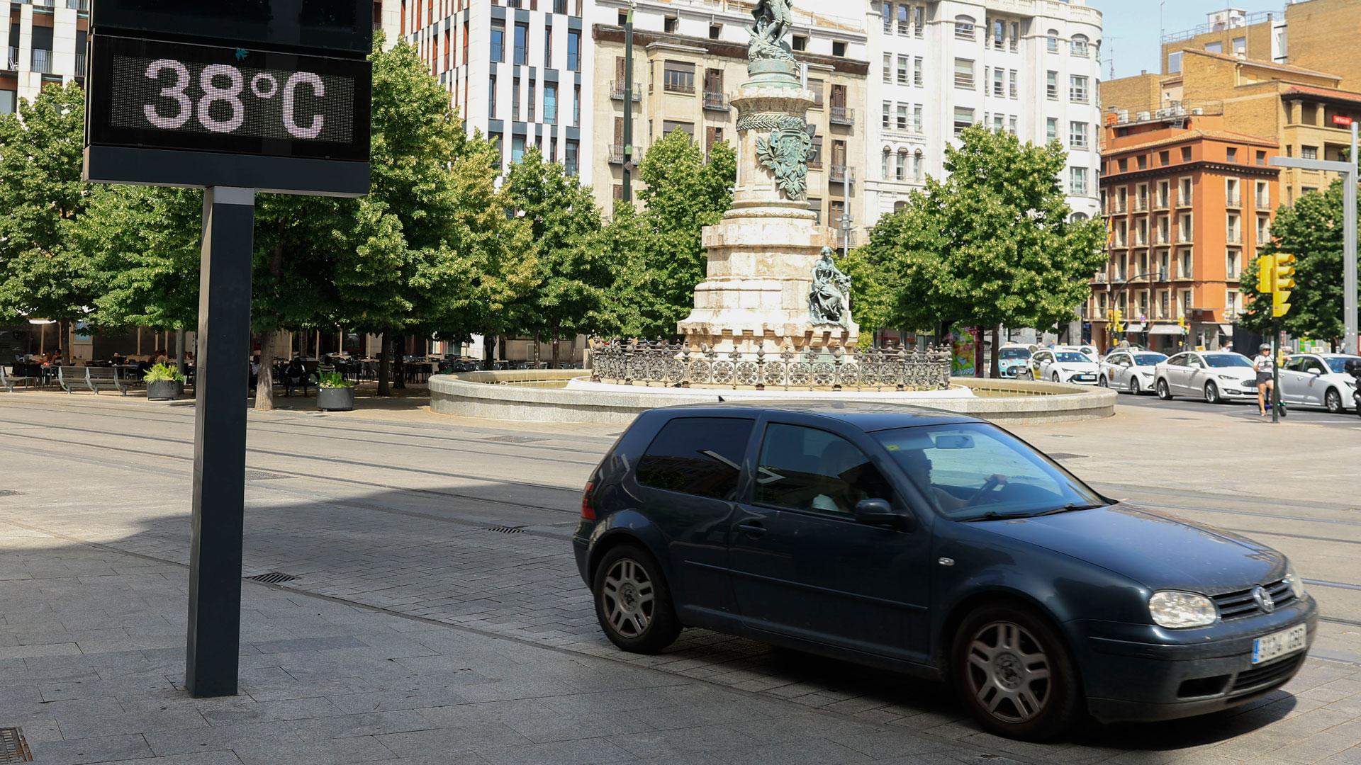 Un coche aparcado junto a un termómetro que marca 38 grados, este lunes en la Plaza de España de Zaragoza