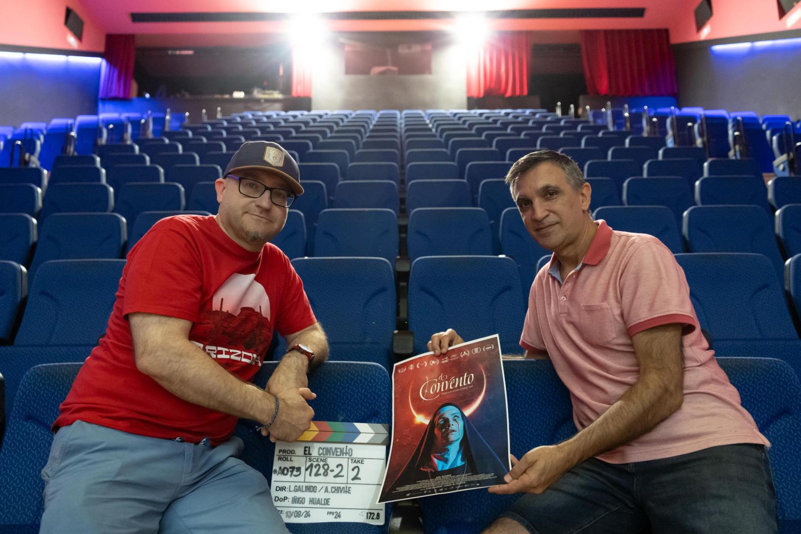 Luis Galindo y Ángel M. Chivite en el cine Avenida de Cintruénigo con la claqueta y un póster de ‘El convento’