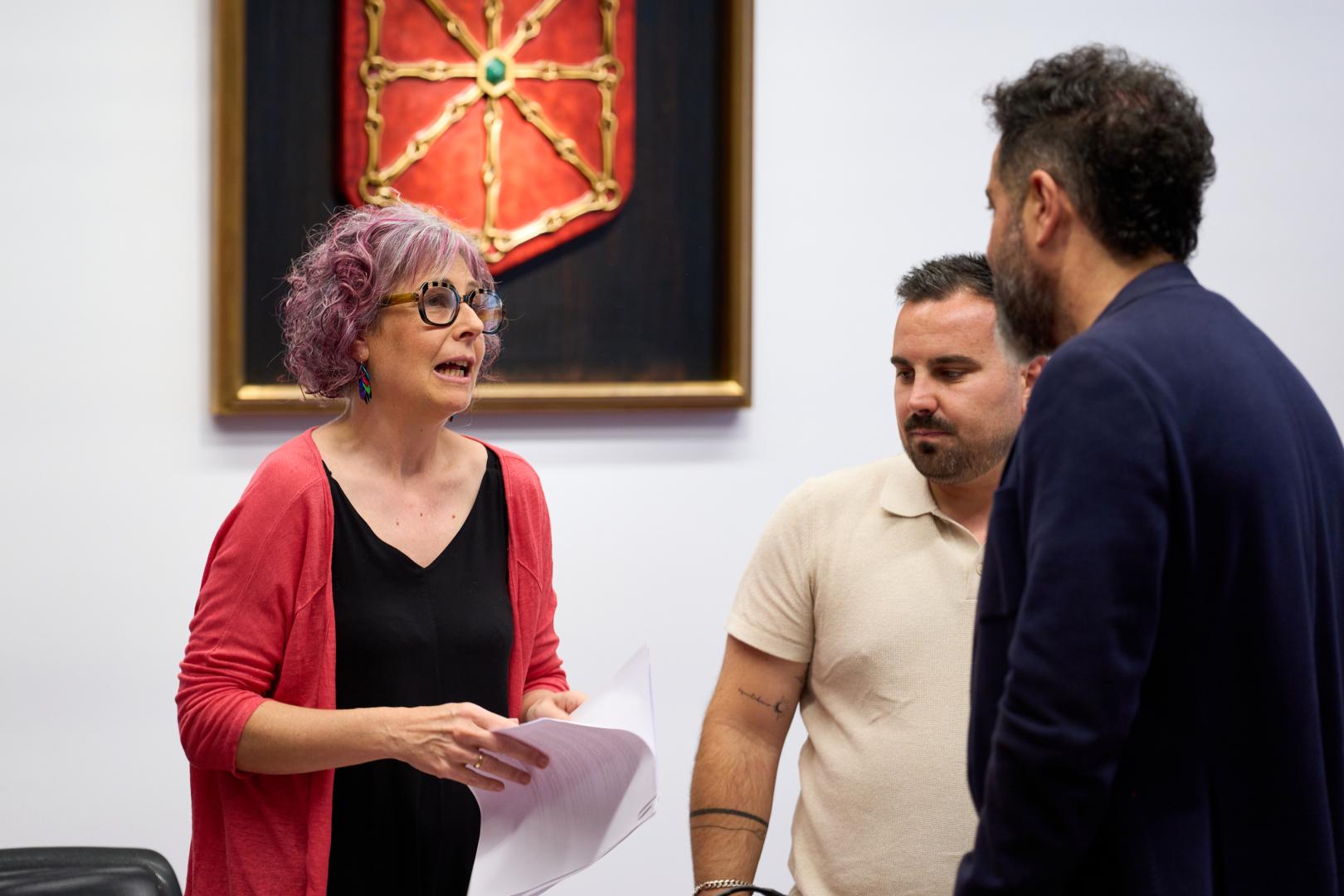 La consejera Rebeca Esnaola habla con los socialistas Ramón Alzórriz y Carlos Mena, antes del comienzo de su comparecencia parlamentaria.