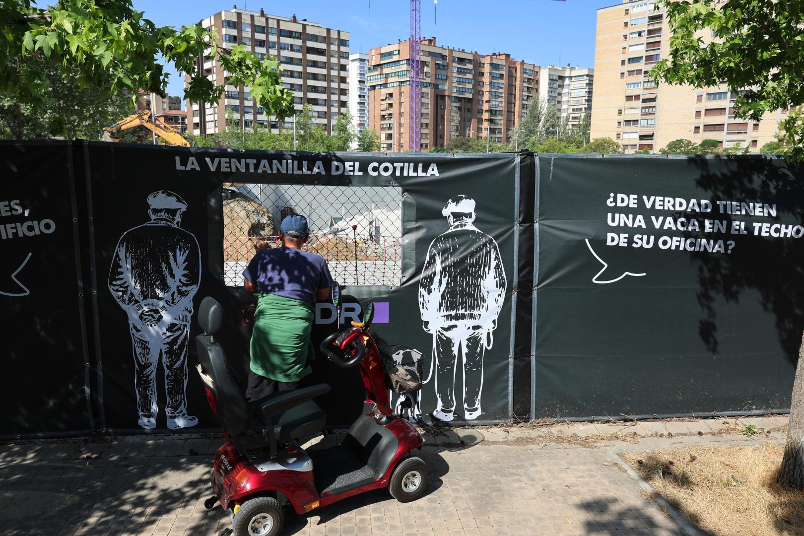 Un vecino observa las obras a través de una de las ventanas que se han habilitado