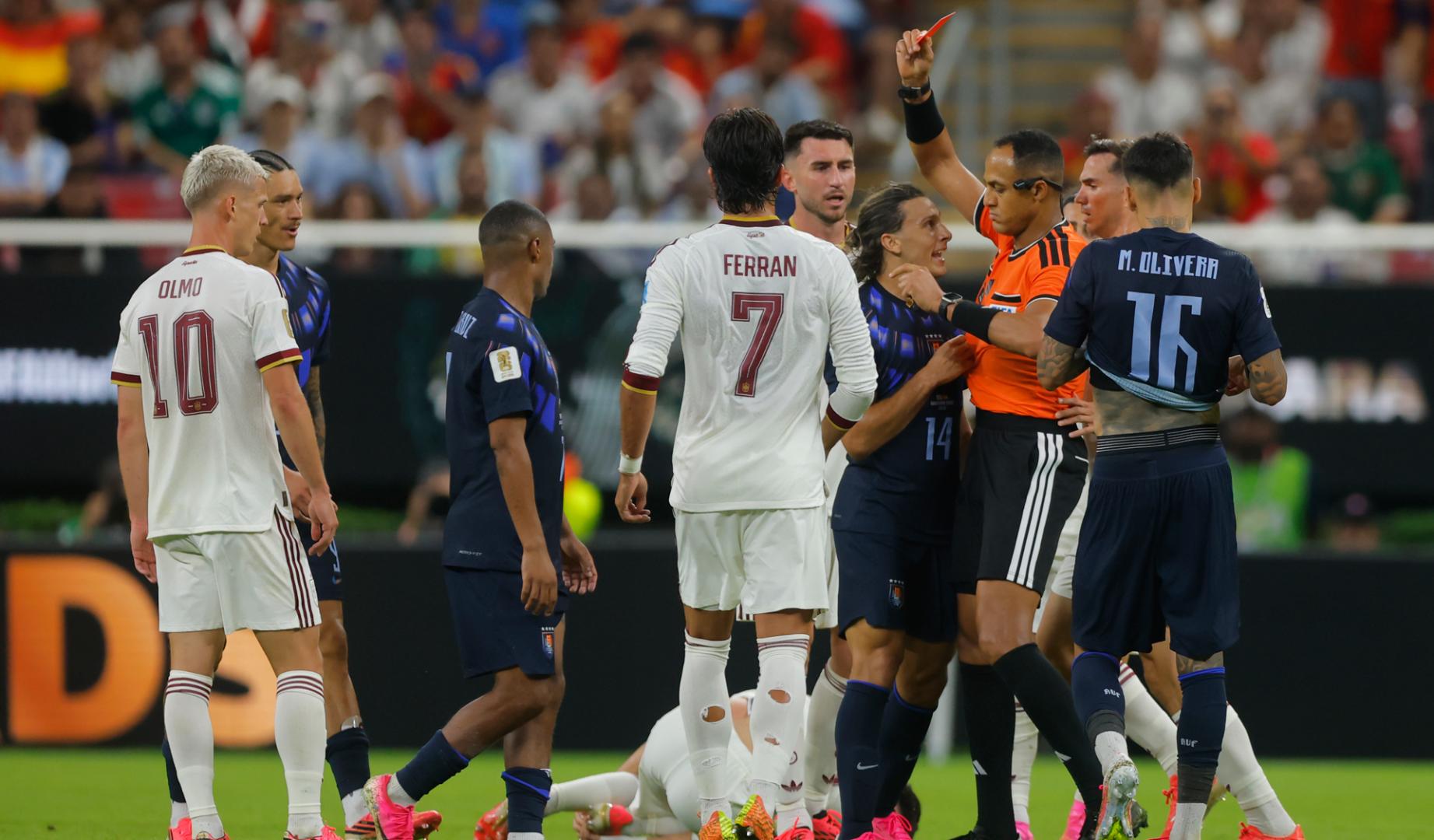 El arbitro Ismail Elfath (2-d) muestra tarjeta roja a Agustín Canobbio (3-d) de Uruguay este viernes, en un partido del grupo H del Mundial de la FIFA 2026 entre Uruguay y España en el estadio Akron en Guadalajara (México)