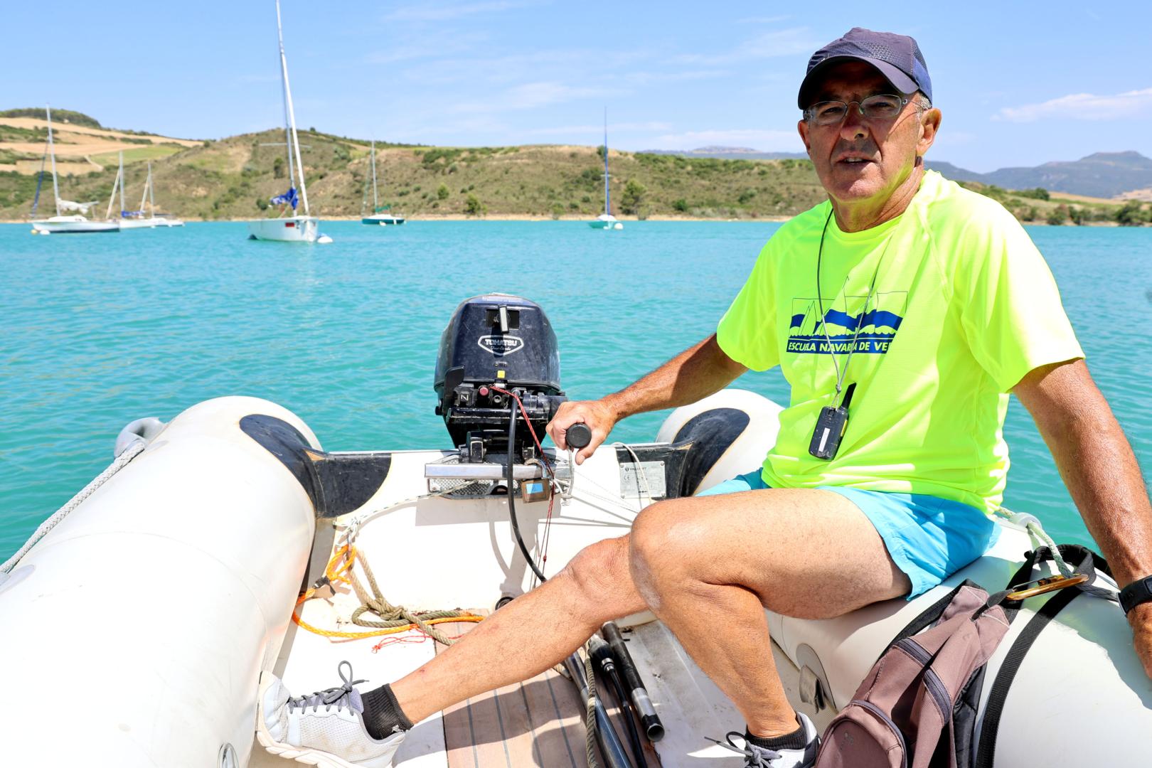 Ángel González, en la zodiac con embarcaciones al fondo en el pantano de Alloz.