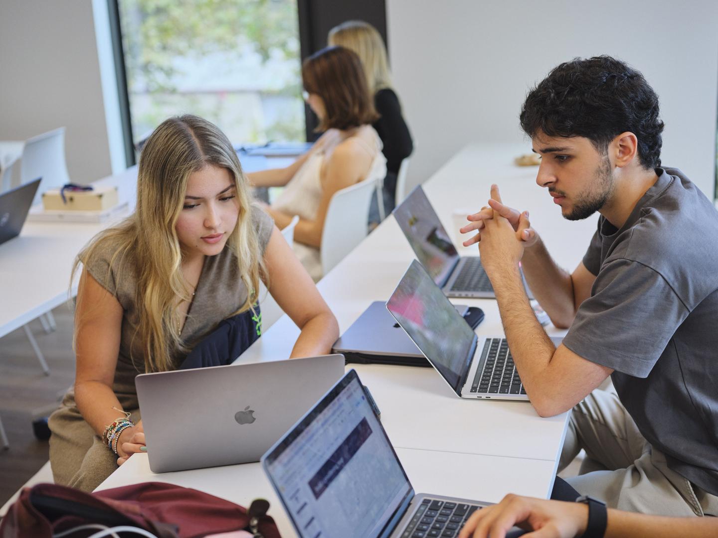Dos universitarios trabajan en el aula