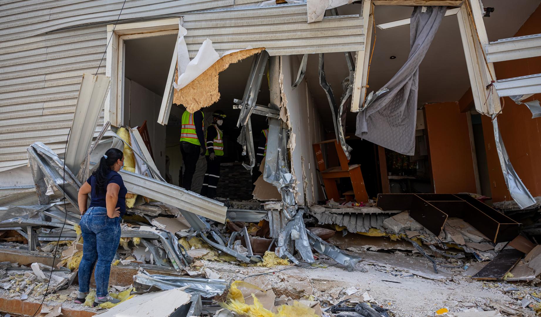 Personas buscan dentro de edificios que hacían parte del programa social Misión Vivienda del presidente fallecido Hugo Chávez destruidos tras los terremotos que asolaron a Venezuela la semana pasada,