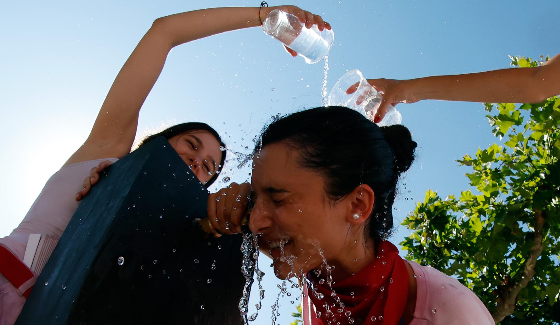 Jóvenes refrescándose en la durante las fiestas de San Fermín en Pamplona