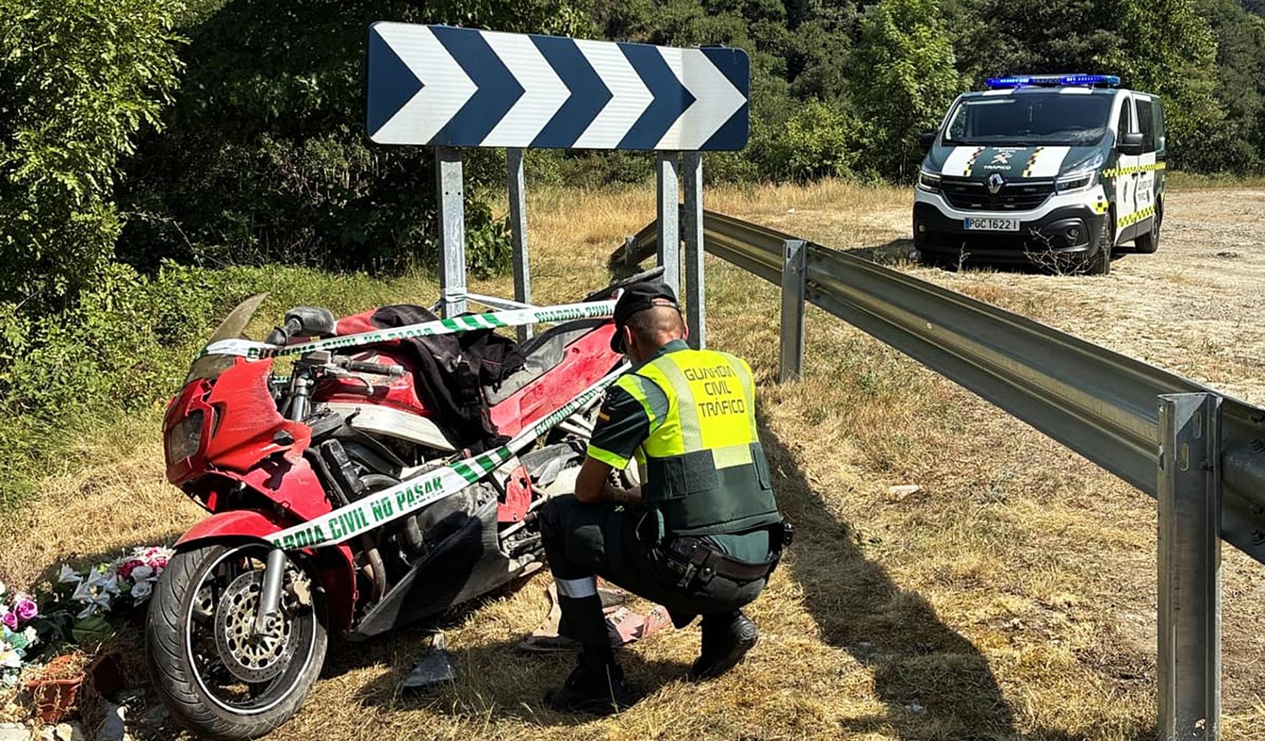 Un agente de la Guardia Civil junto a la motocicleta accidentada