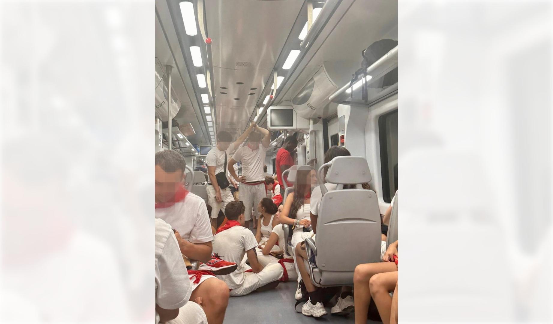 Jóvenes que regresaban a casa tras disfrutar de las fiestas de San Fermín, en los pasillos del tren